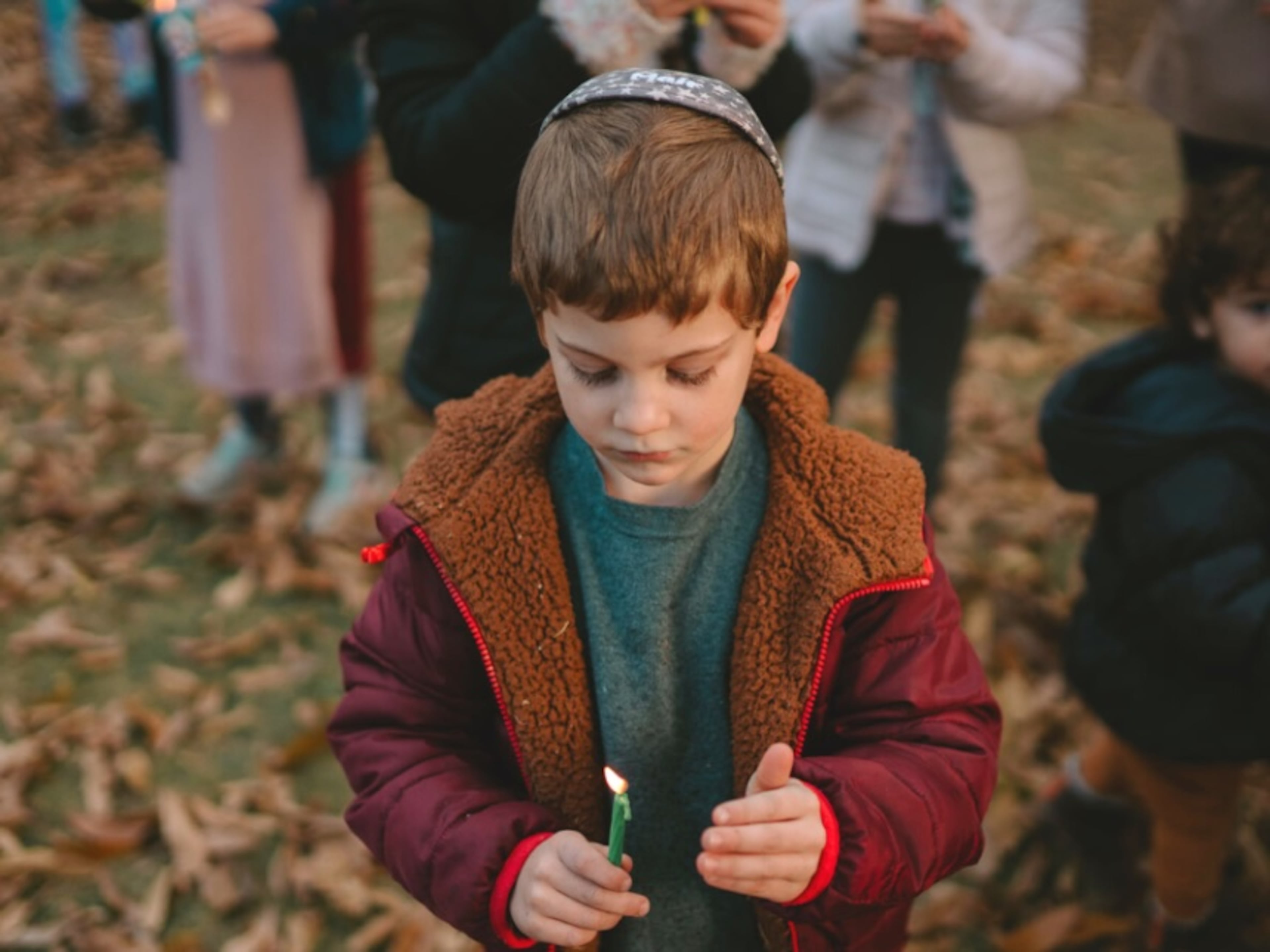 A boy holds on a a candle at the lighting of the menorah ceremony in 2024 at Atlantic Station. (Courtesy of Atlantic Station)