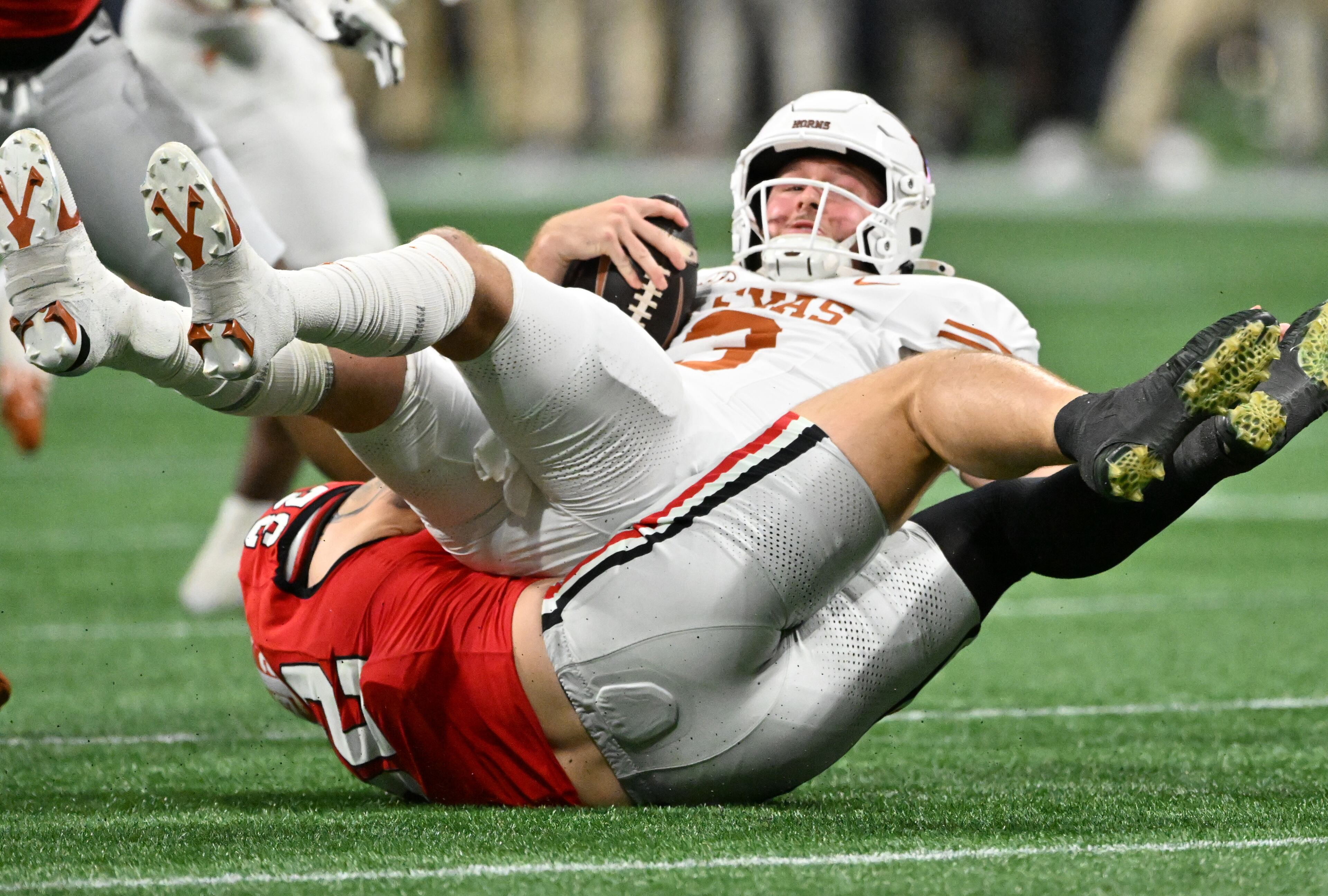 Texas quarterback Quinn Ewers (3) is sacked by Georgia linebacker Chaz Chambliss (32) during the SEC Championship football game at the Mercedes-Benz Stadium, Saturday, December 7, 2024, in Atlanta. (Hyosub Shin / AJC)