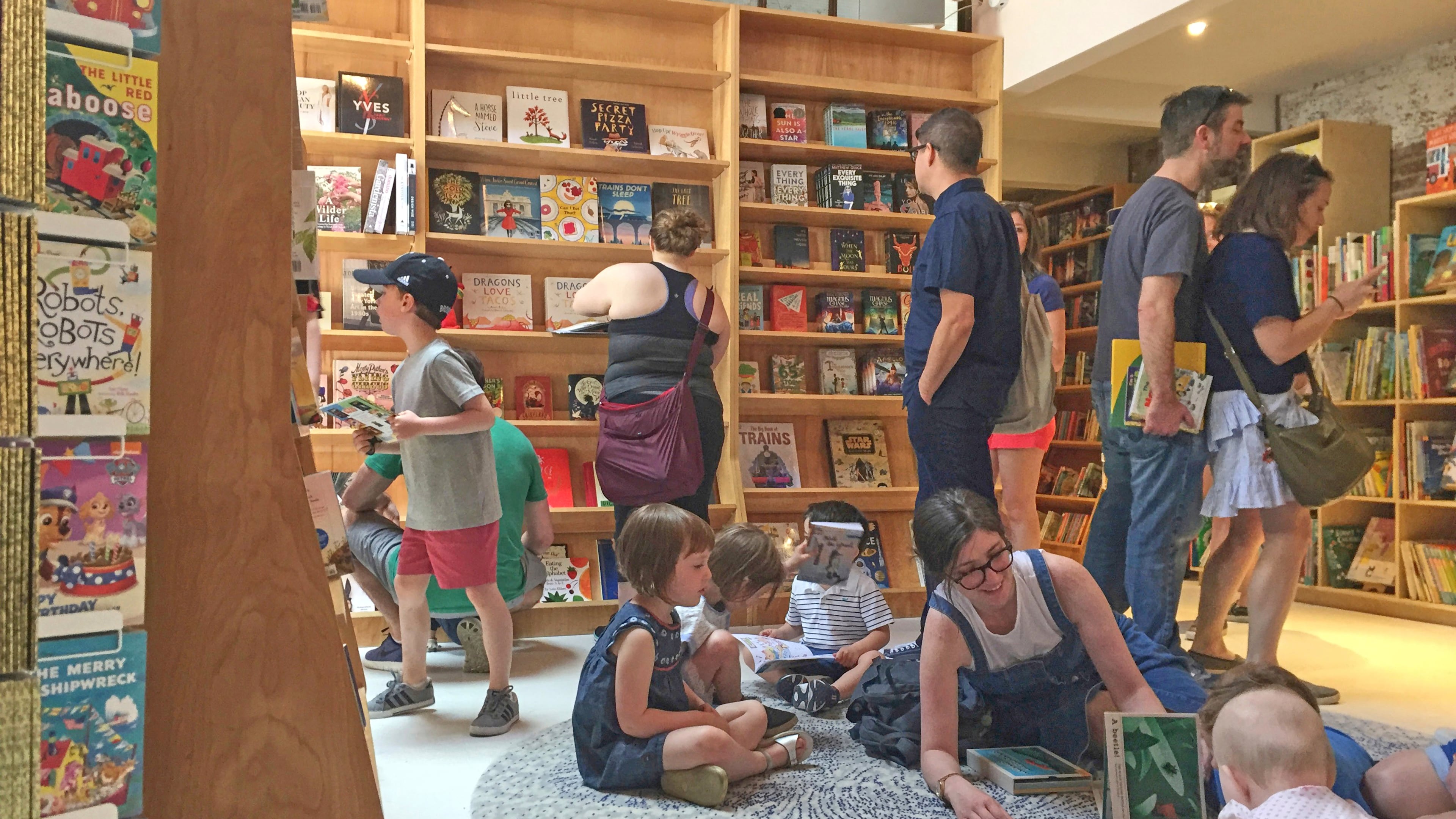 FILE - Customers appear in the children's area of the Books Are Magic bookstore, owned by author Emma Straub, in Brooklyn, New York, on April 29, 2017. (AP Photo/Beth J. Harpaz, File)