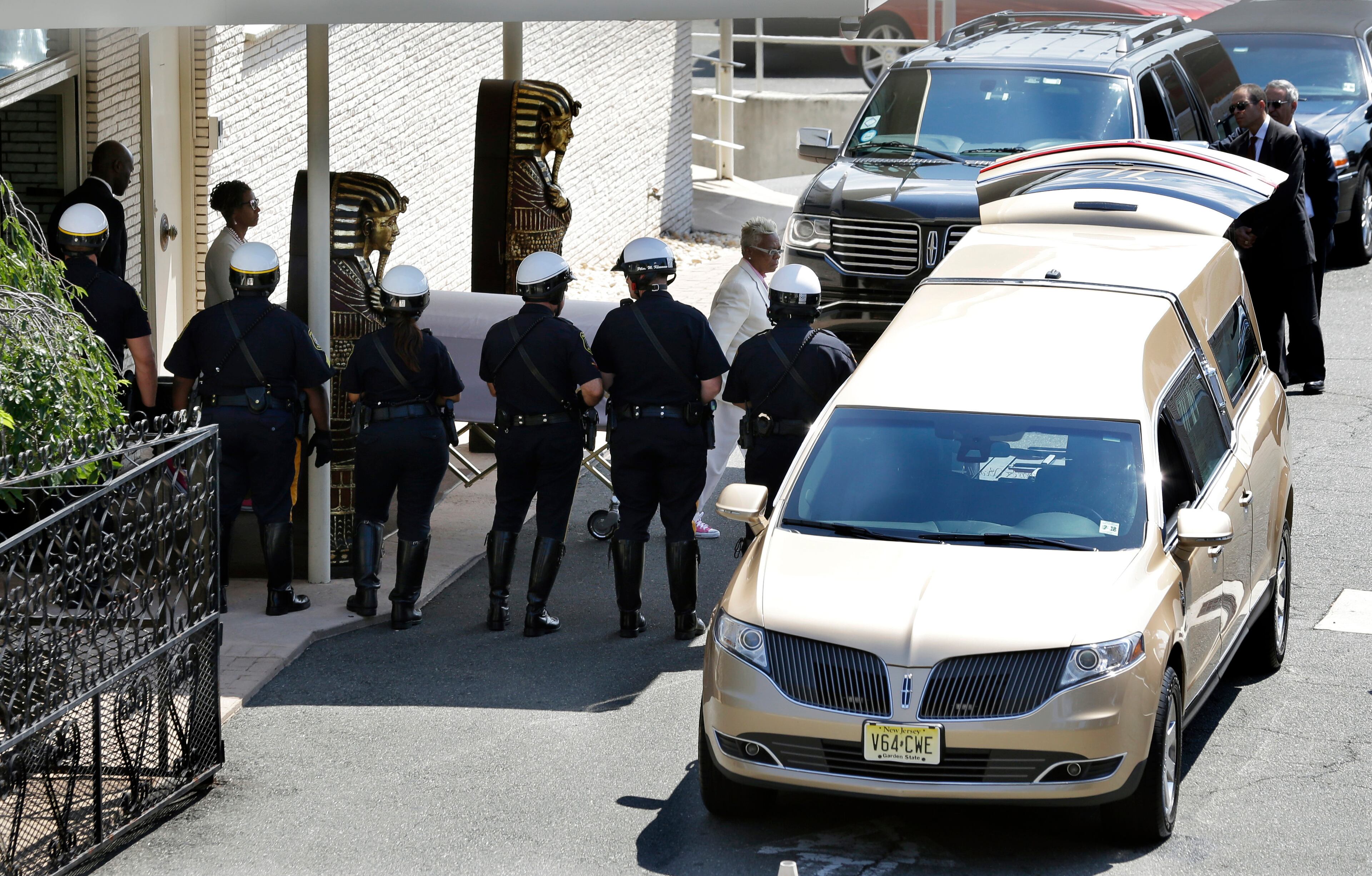 Carolyn Whigham leads Bobbi Kristina Brown's casket to a gold colored hearse after a service at Whigham funeral home in Newark, N.J., early Monday, Aug. 3, 2015. Bobbi Kristina, the only child of Whitney Houston and R&B singer Bobby Brown, died in hospice care July 26, about six months after she was found face-down and unresponsive in a bathtub in her suburban Atlanta townhome. (AP Photo/Mel Evans)