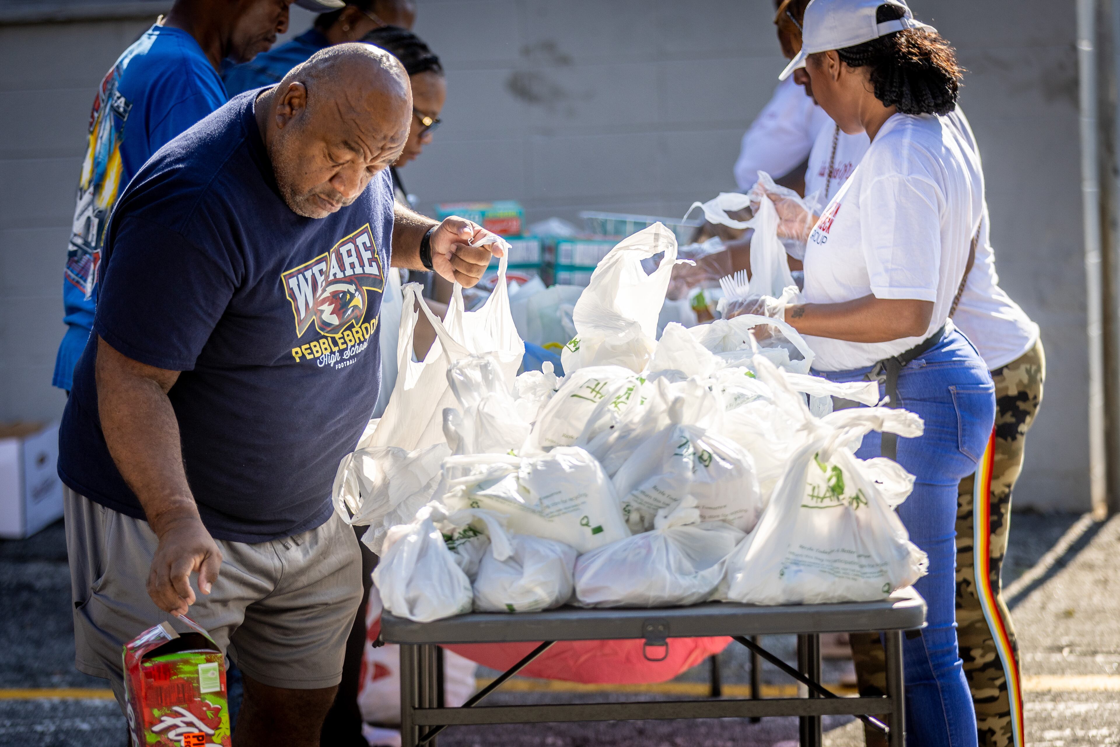 Don Thornton (Left) and other family members assemble over 100 meals before they hand out tacos during Taco Month in an Atlanta parking lot on Saturday, Sept. 23, 2023. (Steve Schaefer/steve.schaefer@ajc.com)