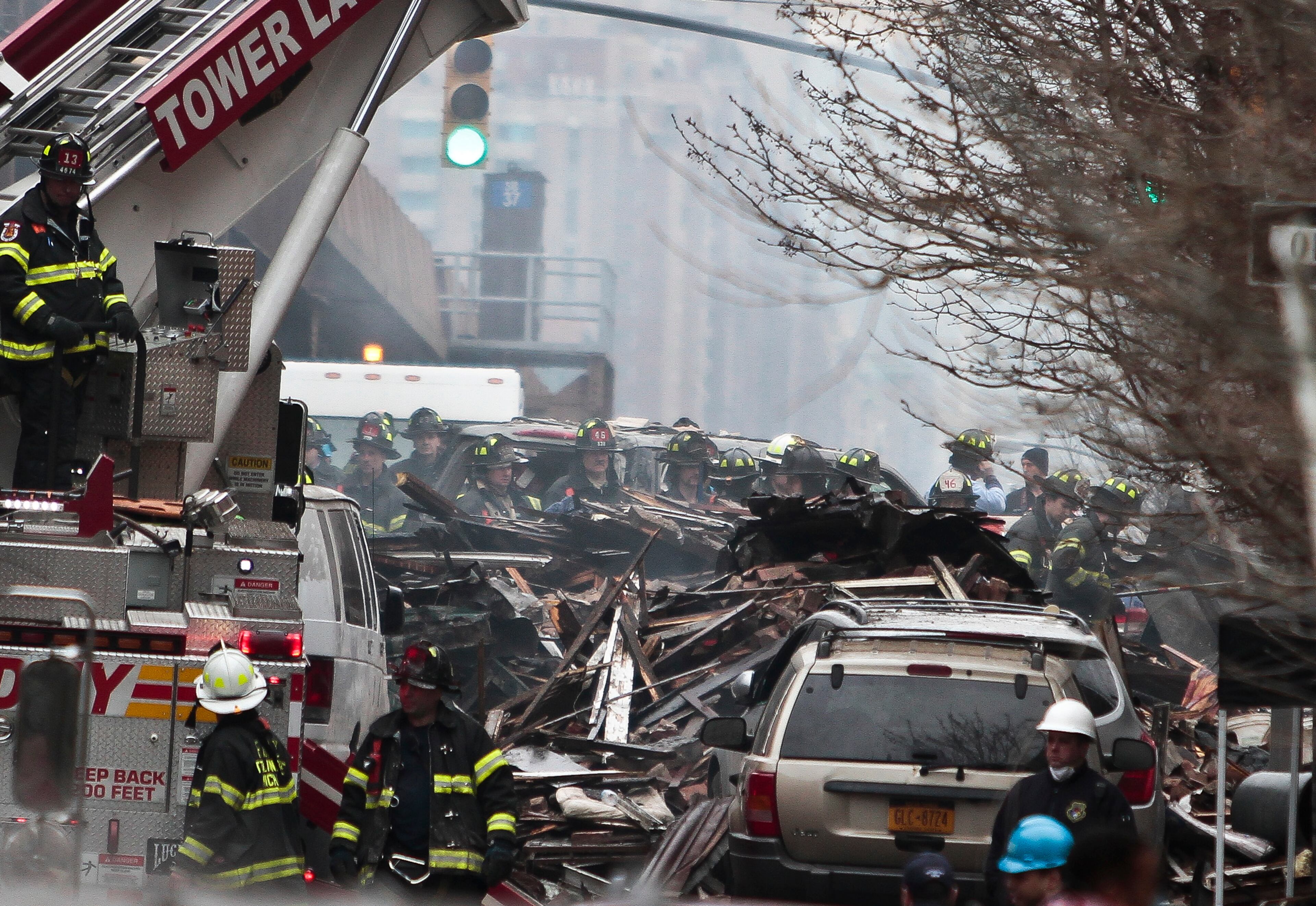 Firefighters continue to investigate and remove debris from an explosion in Harlem, Wednesday, March 12, 2014 in New York. A gas leak triggered an explosion that shattered windows a block away, rained debris onto elevated commuter railroad tracks close by, cast a plume of smoke over the skyline and sent people running into the streets. (AP Photo/Bebeto Matthews)