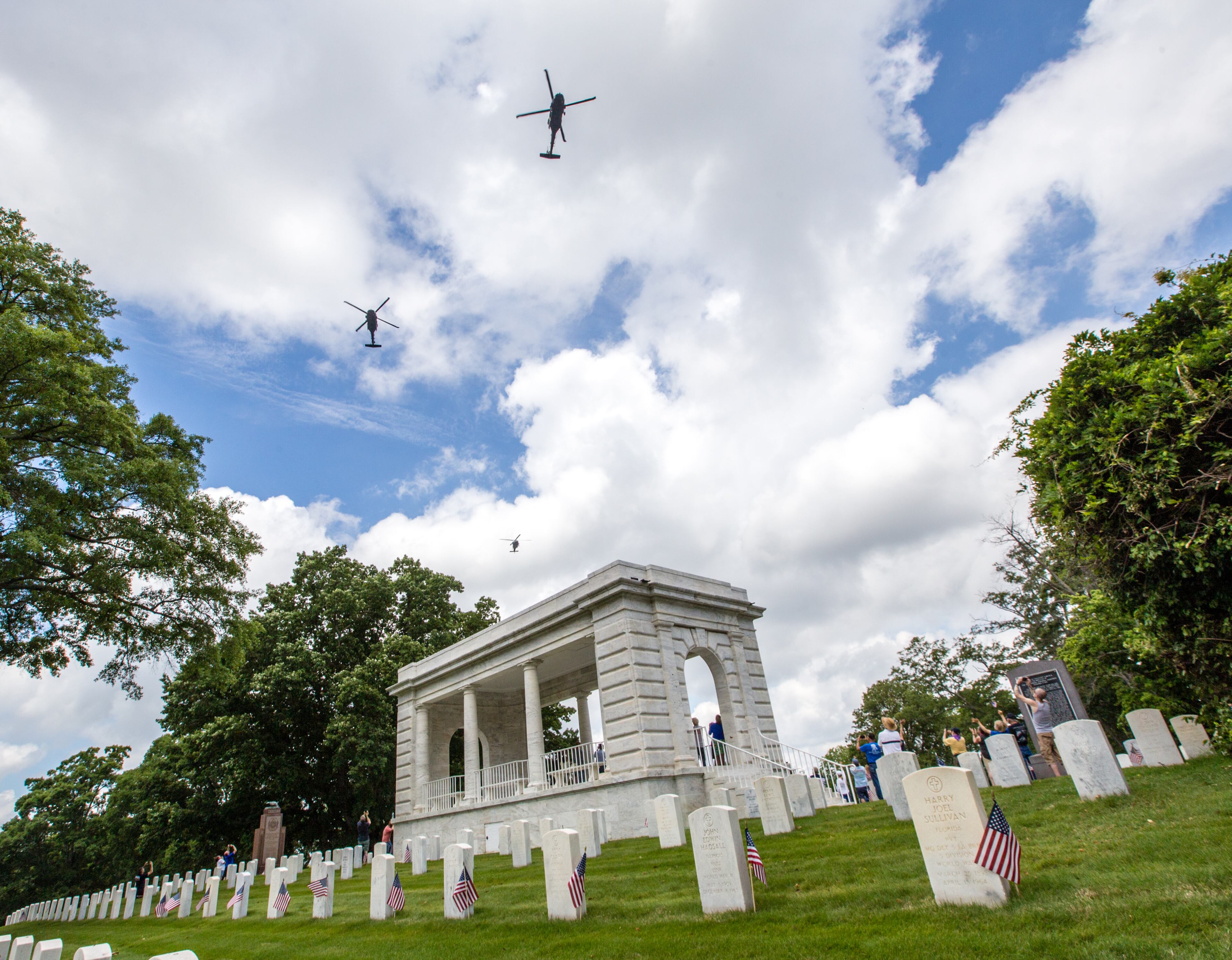 The Marietta National Cemetery did not hold official ceremonies this year, however, small groups gathered to watch the four Blackhawk helicopter flyover on Memorial Day, Monday, May 25, 2020. (Jenni Girtman for The Atlanta Journal Constitution)