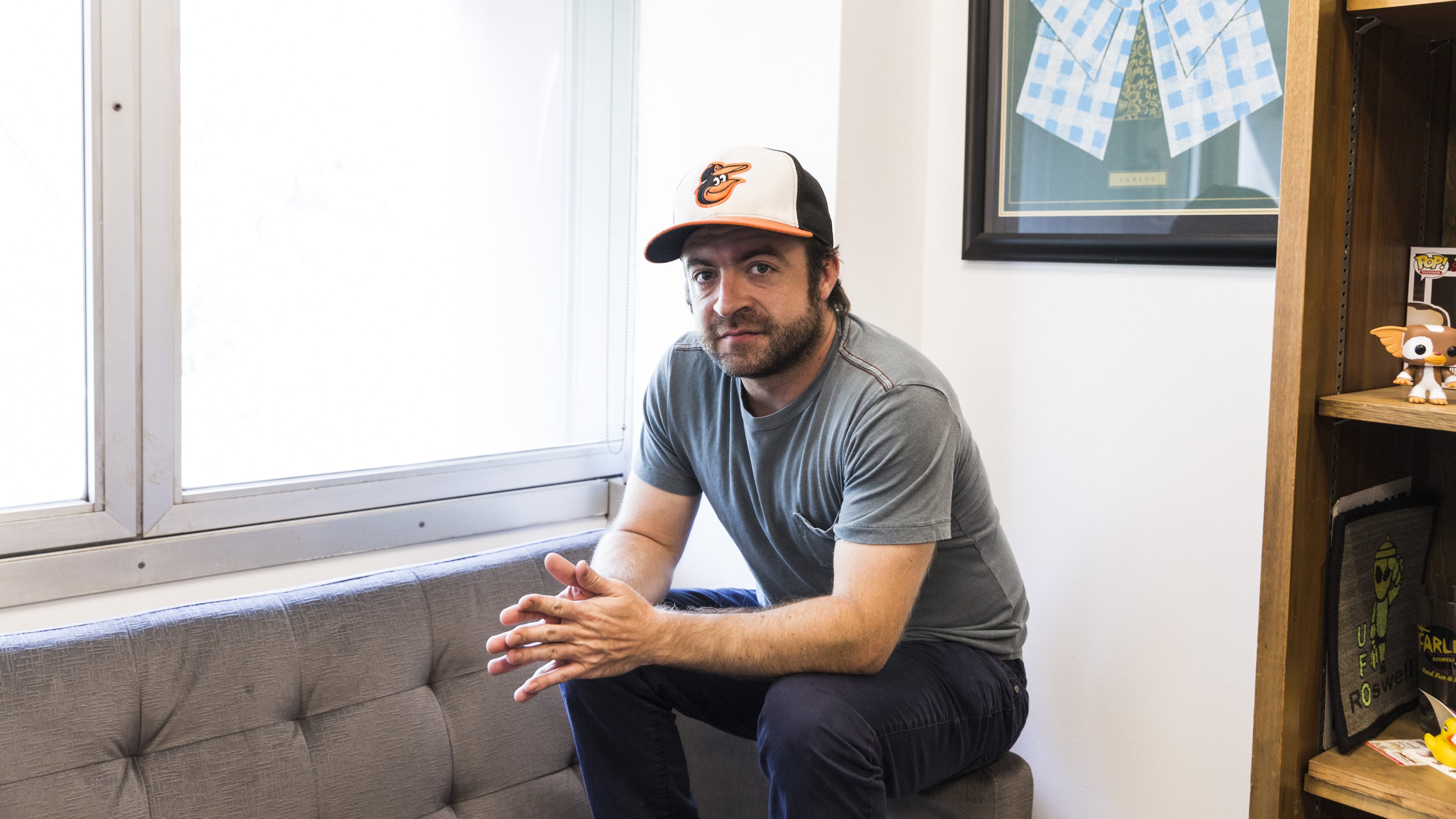 Derek Waters, the co-creator of Comedy Central’s “Drunk History,” in Los Angeles, Aug. 4, 2016. Waters loves going back to Baltimore to see family and friends; the Orioles cap can always be found in his carry-on. “I’m not a jock, I just love my town,” he said. (Emily Berl/The New York Times)