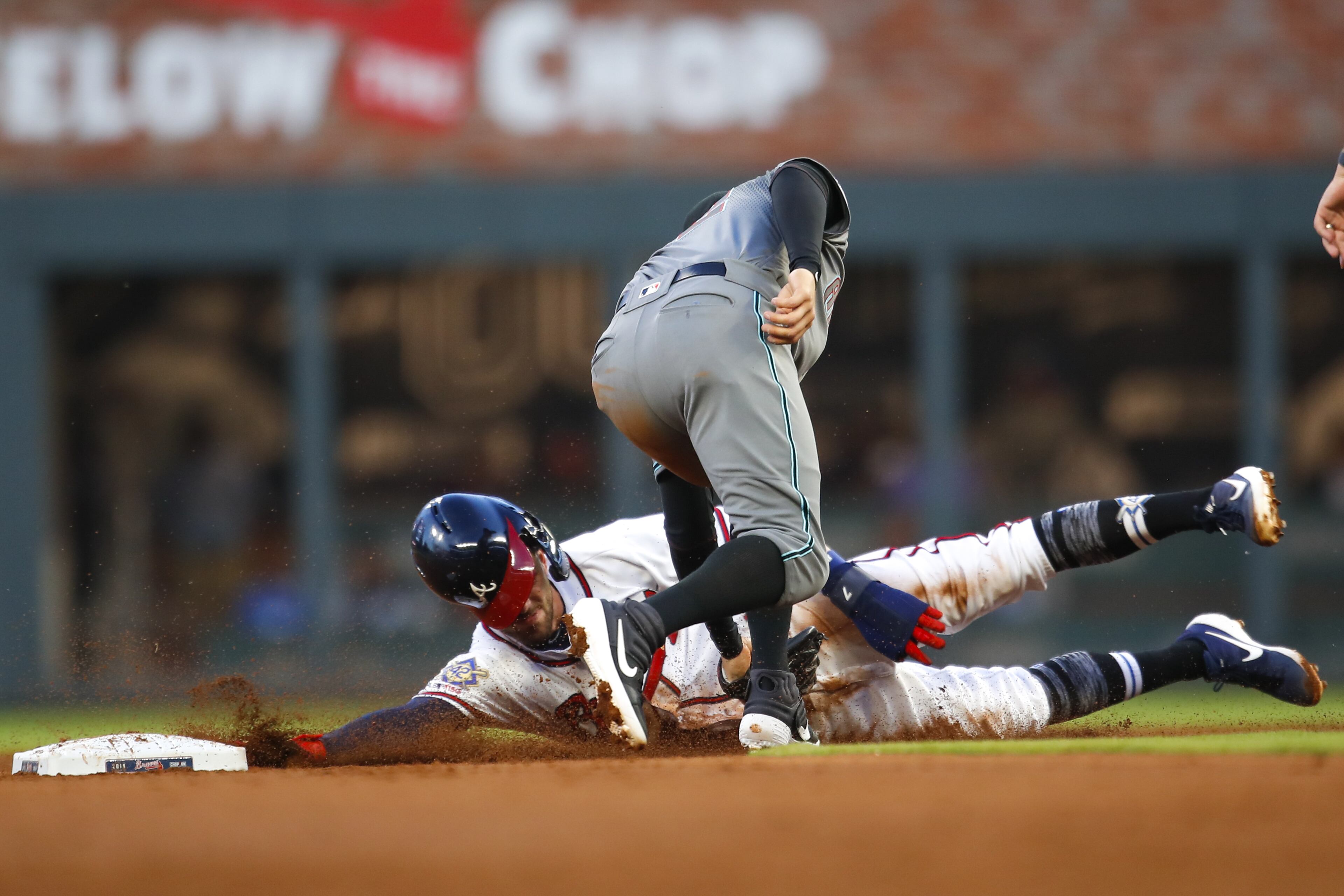 ATLANTA, GA - APRIL 16: Dansby Swanson #7 of the Atlanta Braves is picked off trying to steal second base by Wilmer Flores #41 of the Arizona Diamondbacks in the second inning of an MLB game at SunTrust Park on April 16, 2018 in Atlanta, Georgia. All players are wearing number 42 to honor Jackie Robinson. (Photo by Todd Kirkland/Getty Images)