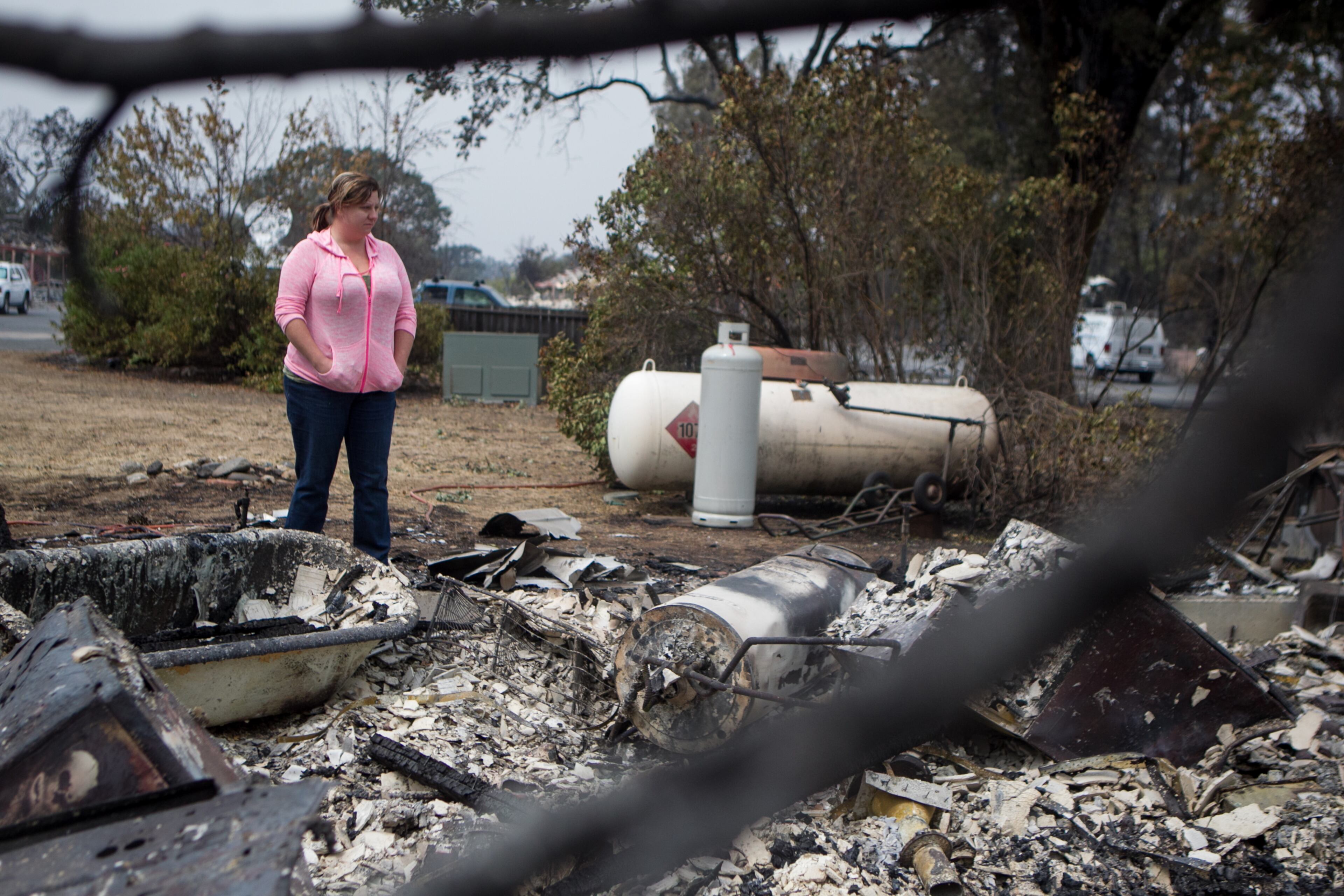 Deanna Hingst looks over what remains of her home after it was burned by a wildfire in Middletown, Calif., Sept. 14, 2015. Despite the efforts of thousands of firefighters, three major fires have consumed 270,000 acres, forcing the evacuation of thousands of people, state officials said. (Ilana Panich-Linsman/The New York Times)