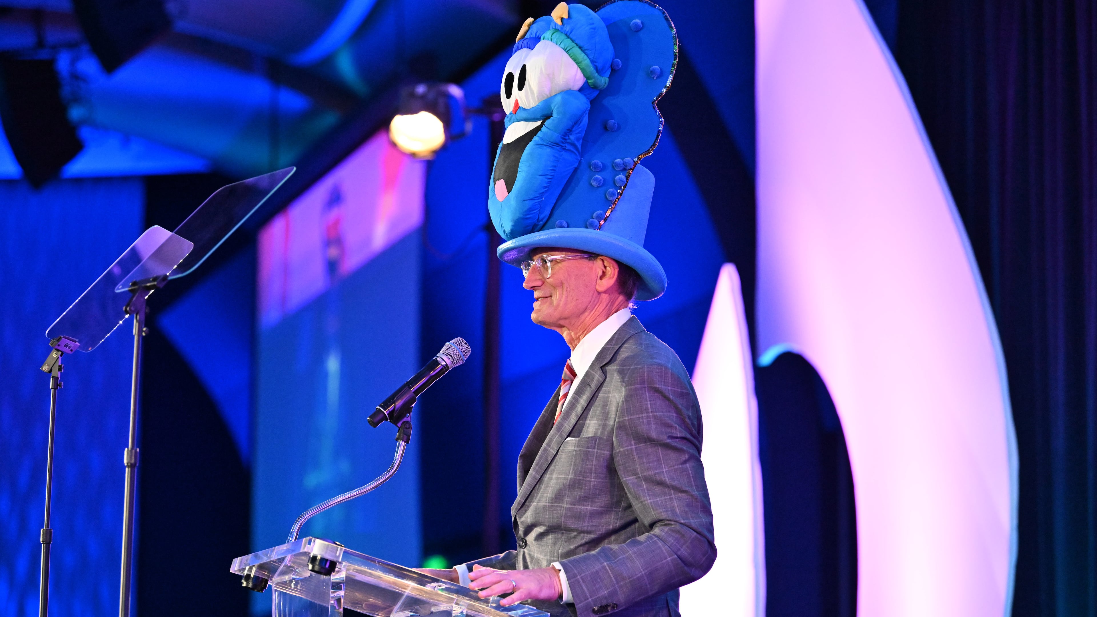 Wearing a hat featuring 1996 Olympics mascot Izzy, A.J. Robinson speaks during the Central Atlanta Progress and Atlanta Downtown Improvement District annual meeting and awards celebration Wednesday, March 11, 2026, at the Georgia Aquarium in Atlanta. Robinson is president of both organizations. (Hyosub Shin/AJC)