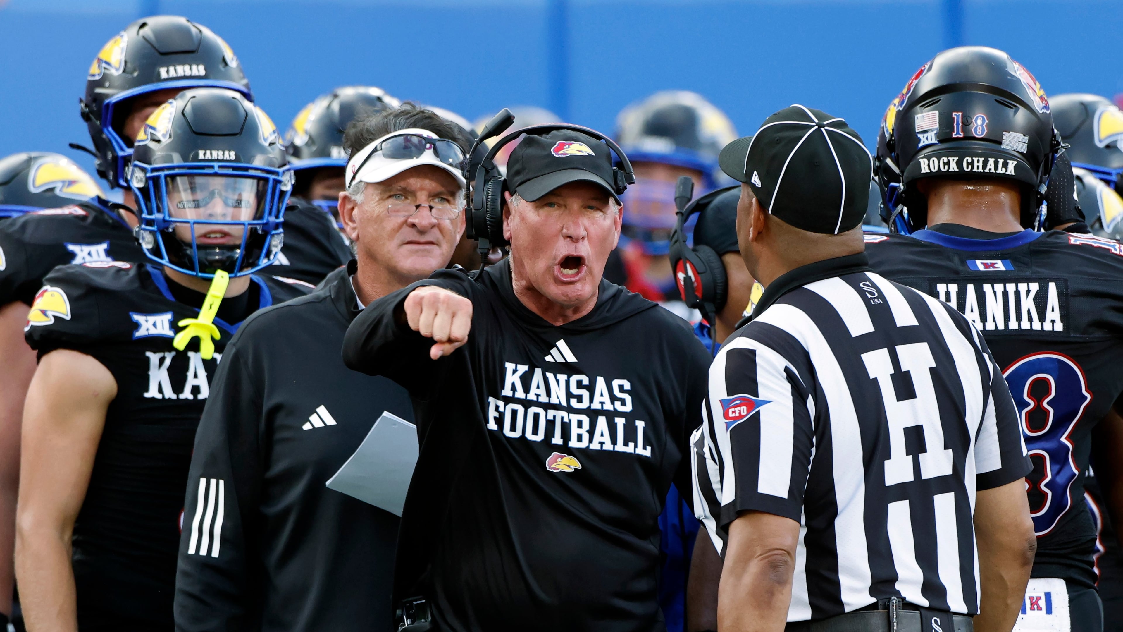 FILE - Kansas head coach Lance Leipold, center, disputes a call by an official during the first half of an NCAA collage football game against West Virginia Sept. 20, 2025, in Lawrence, Kan. (AP Photo/Colin E. Braley, File)