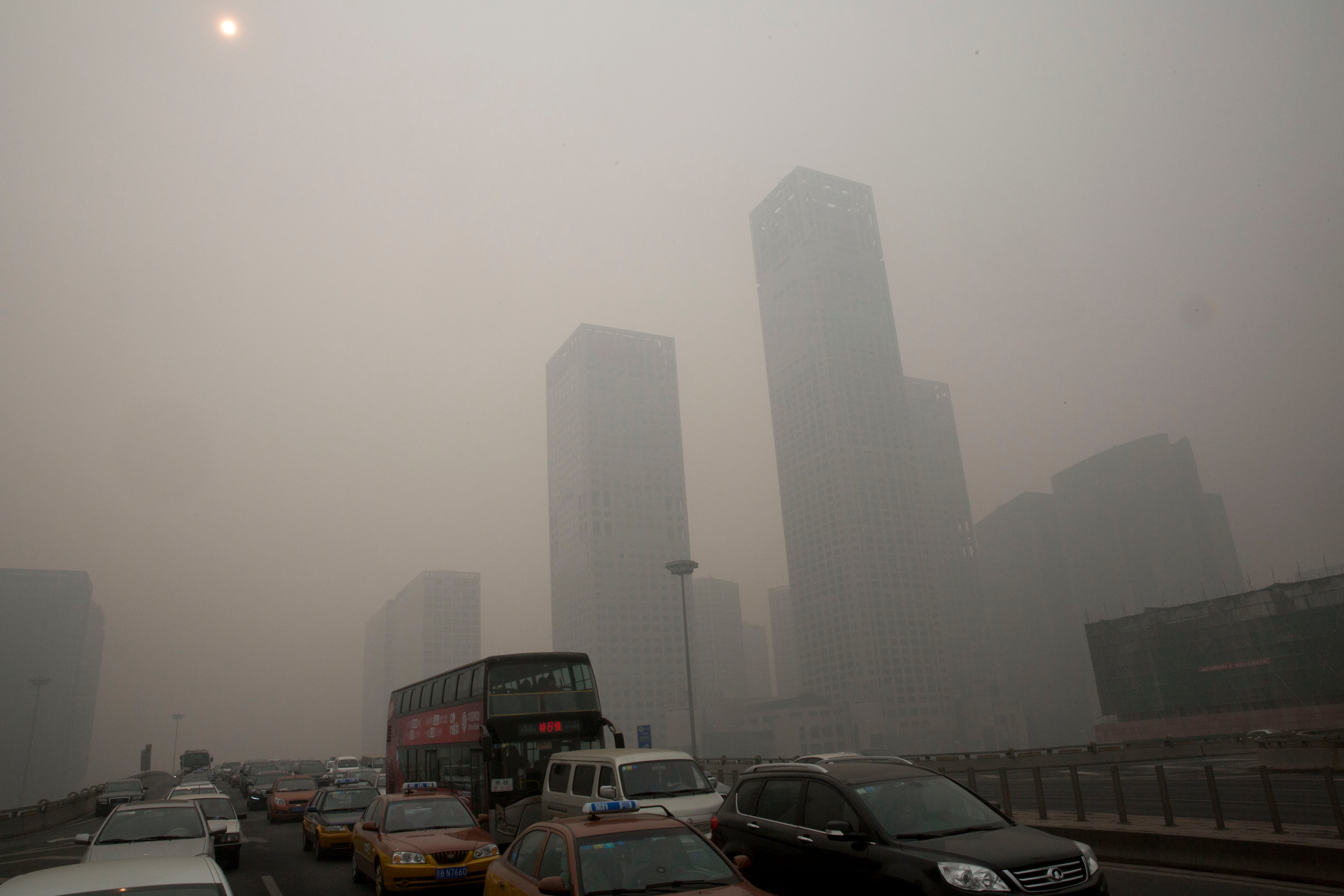 Vehicles clog a highway during a hazy day in Beijing, China, Wednesday, Feb. 26, 2014. Beijing remained cloaked in hazardous white pollution hiding much of its skyline Wednesday, despite the announced closures or production cuts at 147 of the city's industrial plants.