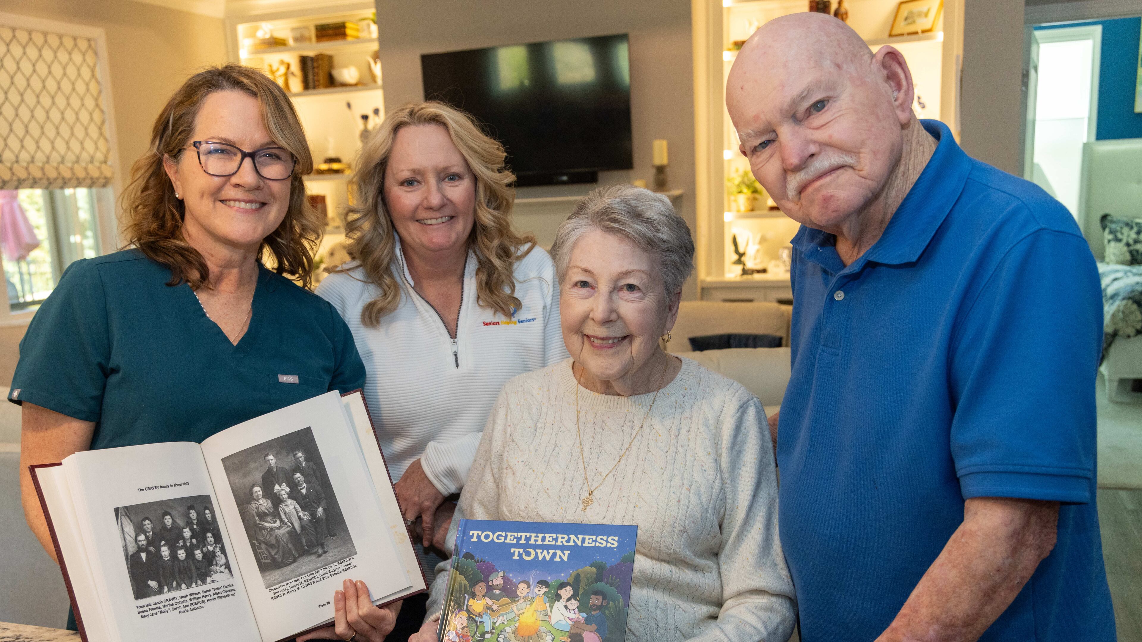 Beth Wilson (from left), Tina Boggs and Ruth and Bill Renner show off their books at the Renners' Gainesville home. Wilson is holding Bill Renner's genealogy book while Ruth Renner holds Wilson's new book. Wilson brought her first published children's book to the Renners' home on release day, and they were her first buyers. PHIL SKINNER FOR THE ATLANTA JOURNAL-CONSTITUTION