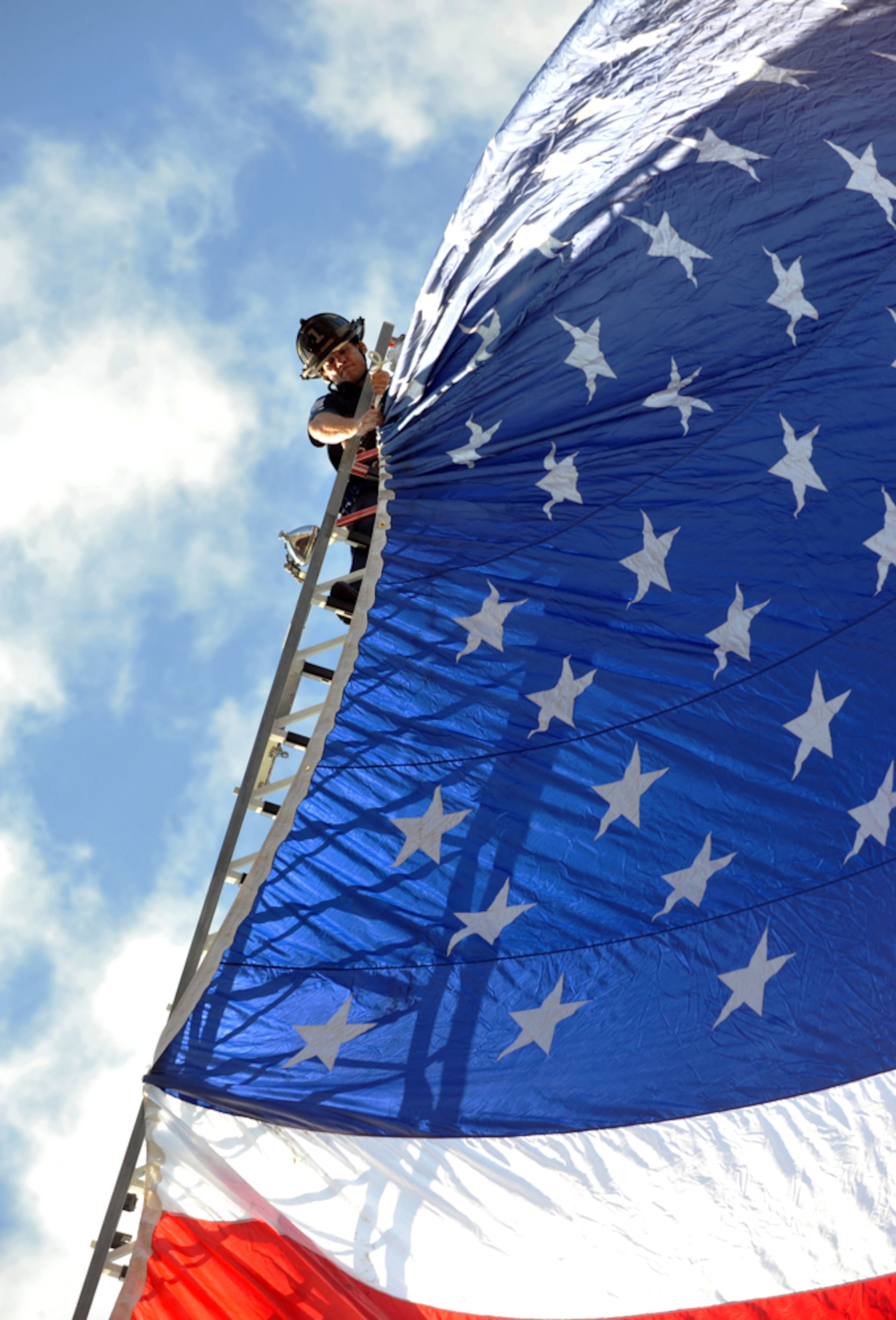 After 11 years, it was becoming difficult to get an original image from the annual 9-11 remembrances. This one jumped out at me as the fire department was hanging the flag prior to the ceremony. September 10, 2012 ATLANTA Atlanta Fire Rescue Sgt Ferrell Davis secures a 50-foot American flag from the raised ladder of Truck 1 before the citiy� 9-11 ceremony Monday, September 10, 2012. The ceremony was held in conjunction with the Atlanta Police Department at the Public Safety Headquarters in the courtyard at 226 Peachtree Street, SW. Atlanta Police Chief George N. Turner provided opening remarks. Public Safety Chair, Council Member Michael Bon, police and officials laid a wreath before closing remarks by Atlanta Fire Rescue Chief Kelvin J. Cochran. KENT D. JOHNSON / KDJOHNSON@AJC.COM NIKON D3, ISO 500, 1/320, f9, 180mm