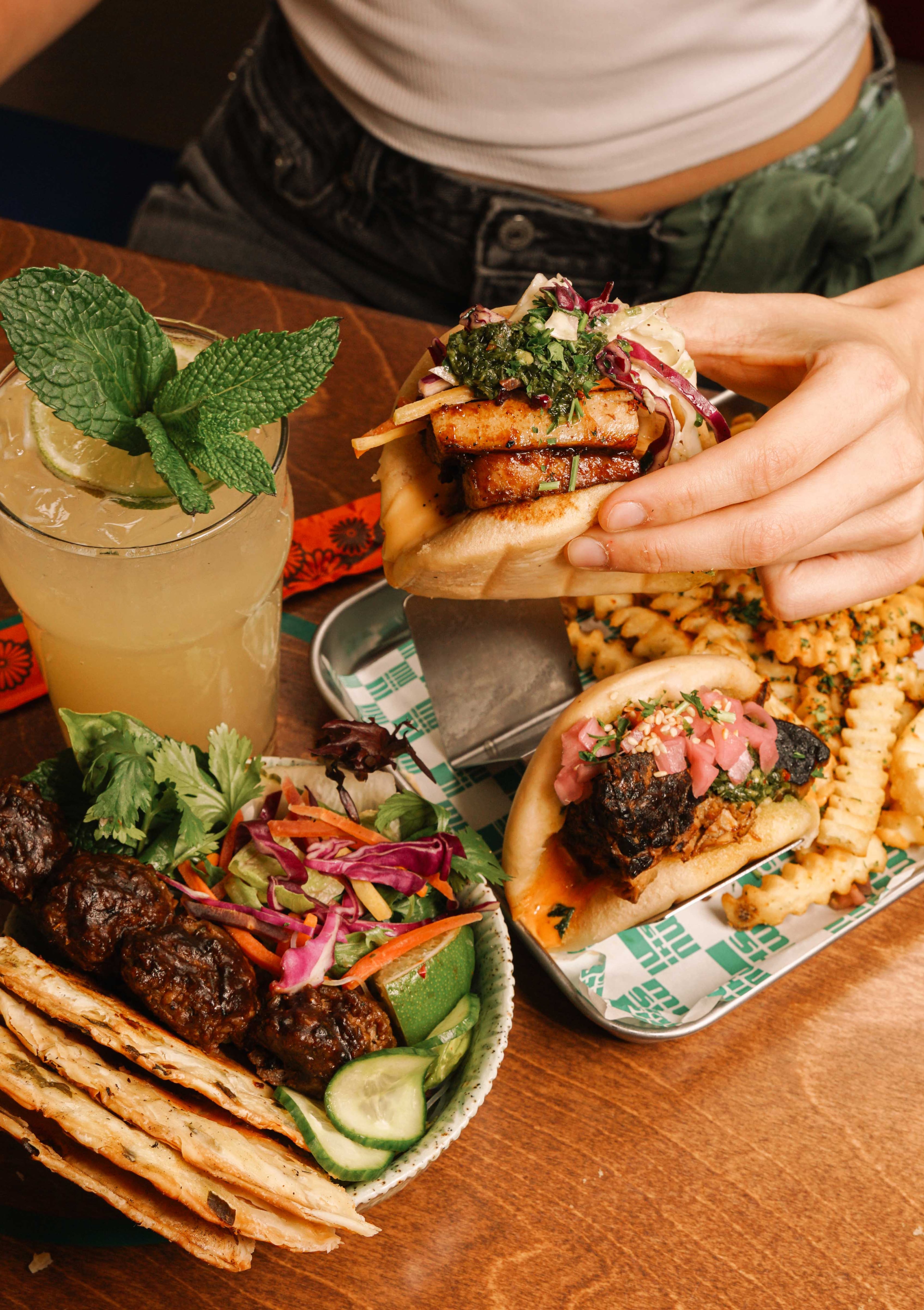Mushi Ni's stand-alone location in Inman Park specializes in bao buns. An appetizer of beef bun cha, or beef meatballs with scallion pancakes, sits in the foreground. (Courtesy of Drew Perlmutter/Mushi Ni)