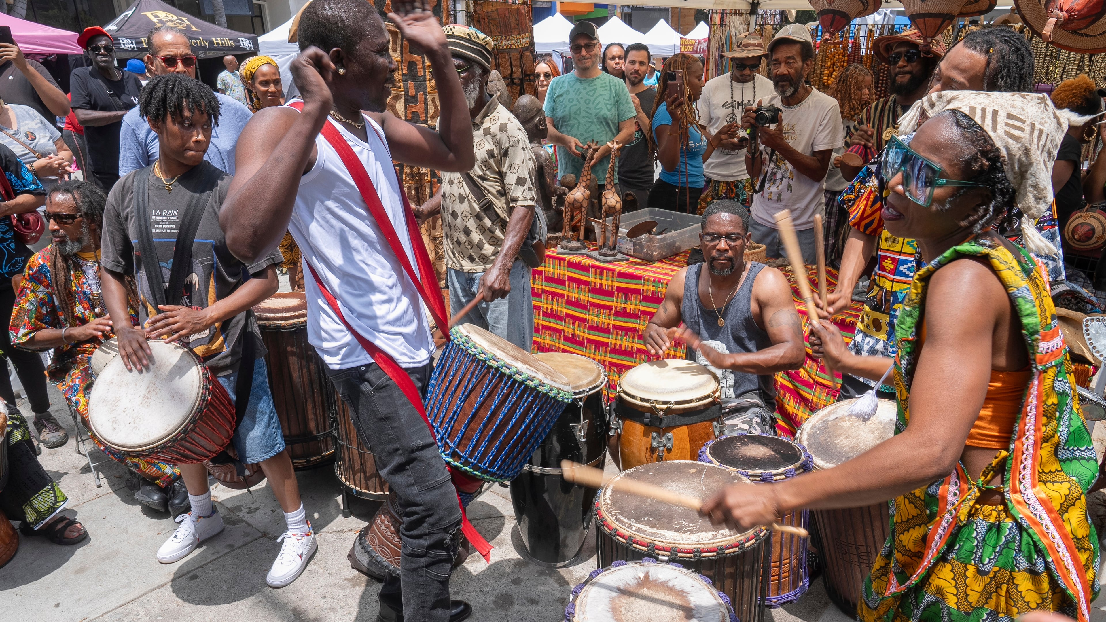 FILE - Drummers form a circle around Sika Dwimfo, better known as the, "Godfather of Leimert Park," during the neighborhood's Juneteenth celebration, June 19, 2024, at Leimert Park in Los Angeles. (AP Photo/Damian Dovarganes, File)