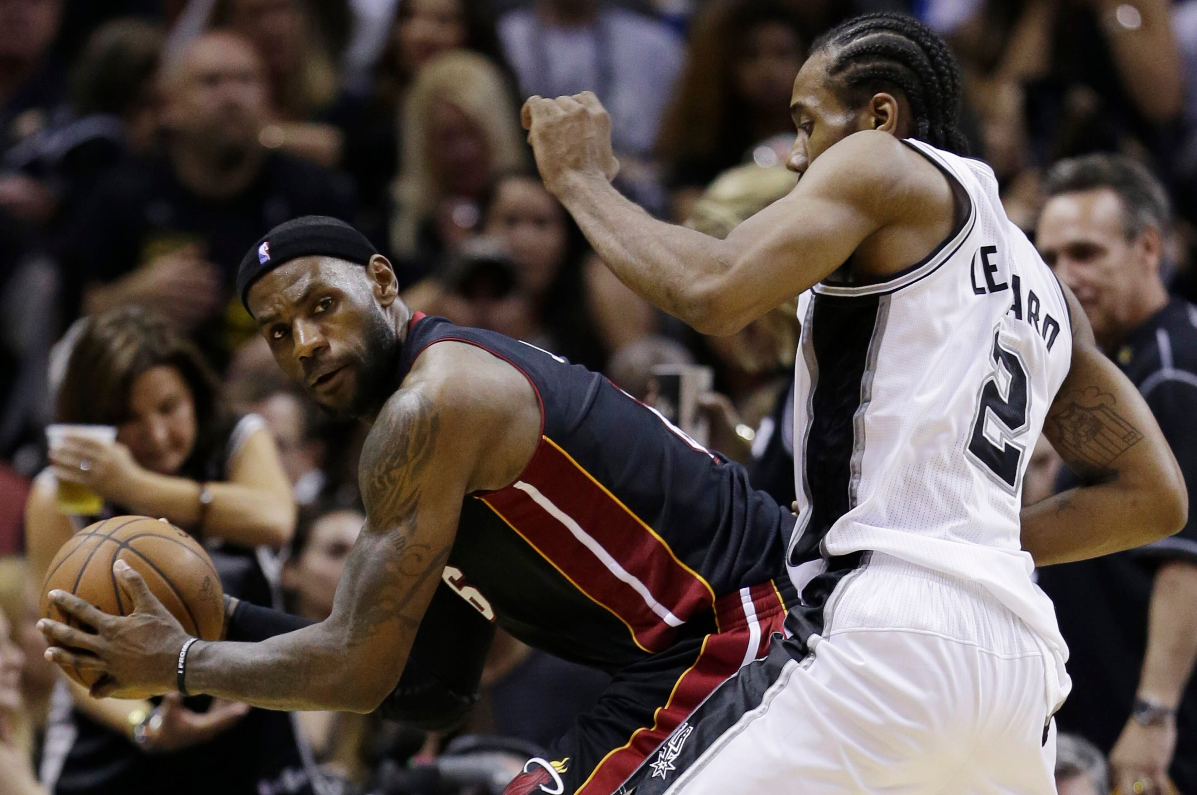 Miami Heat forward LeBron James (6) looks past defender San Antonio Spurs forward Kawhi Leonard (2) during the second half in Game 5 of the NBA basketball finals on Sunday, June 15, 2014, in San Antonio. (AP Photo/David J. Phillip)