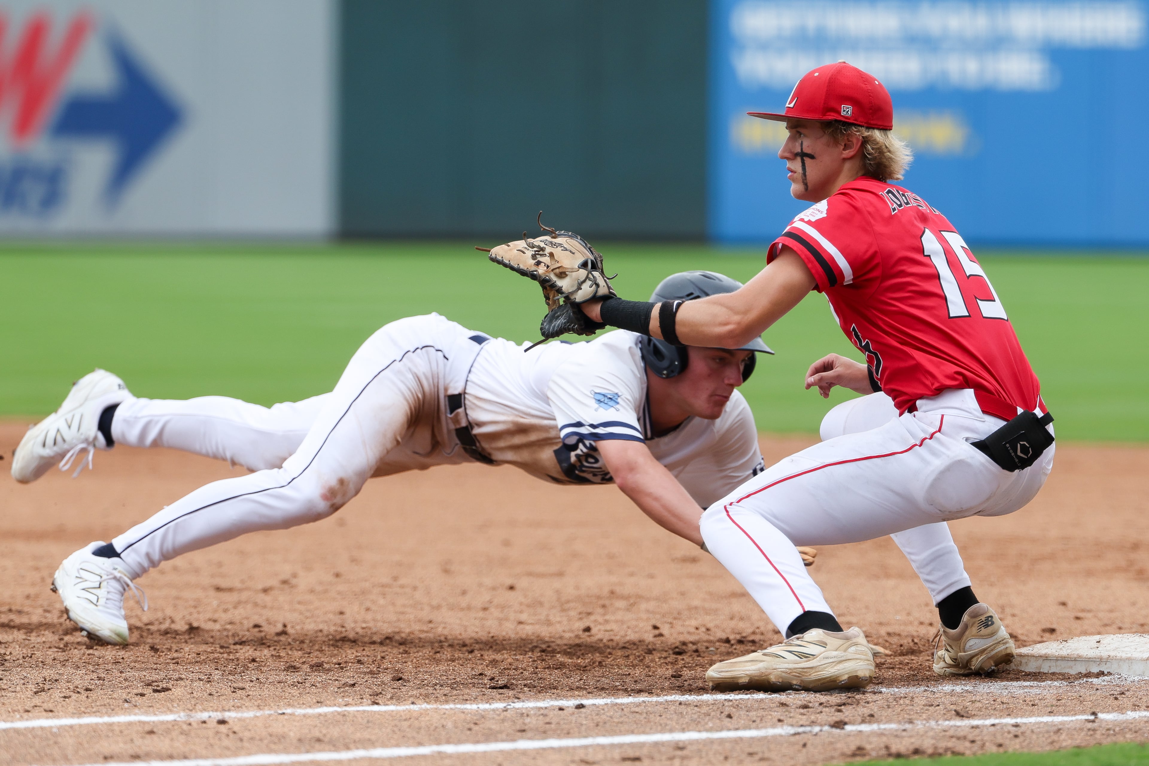 Pope’s Jensen Morneau (left) slides back to first base during Game 2 of their GHSA Class 5A baseball championship series against Loganville at Gwinnett Field on Tuesday, May 26, 2026, in Lawrenceville. (Arvin Temkar/AJC)