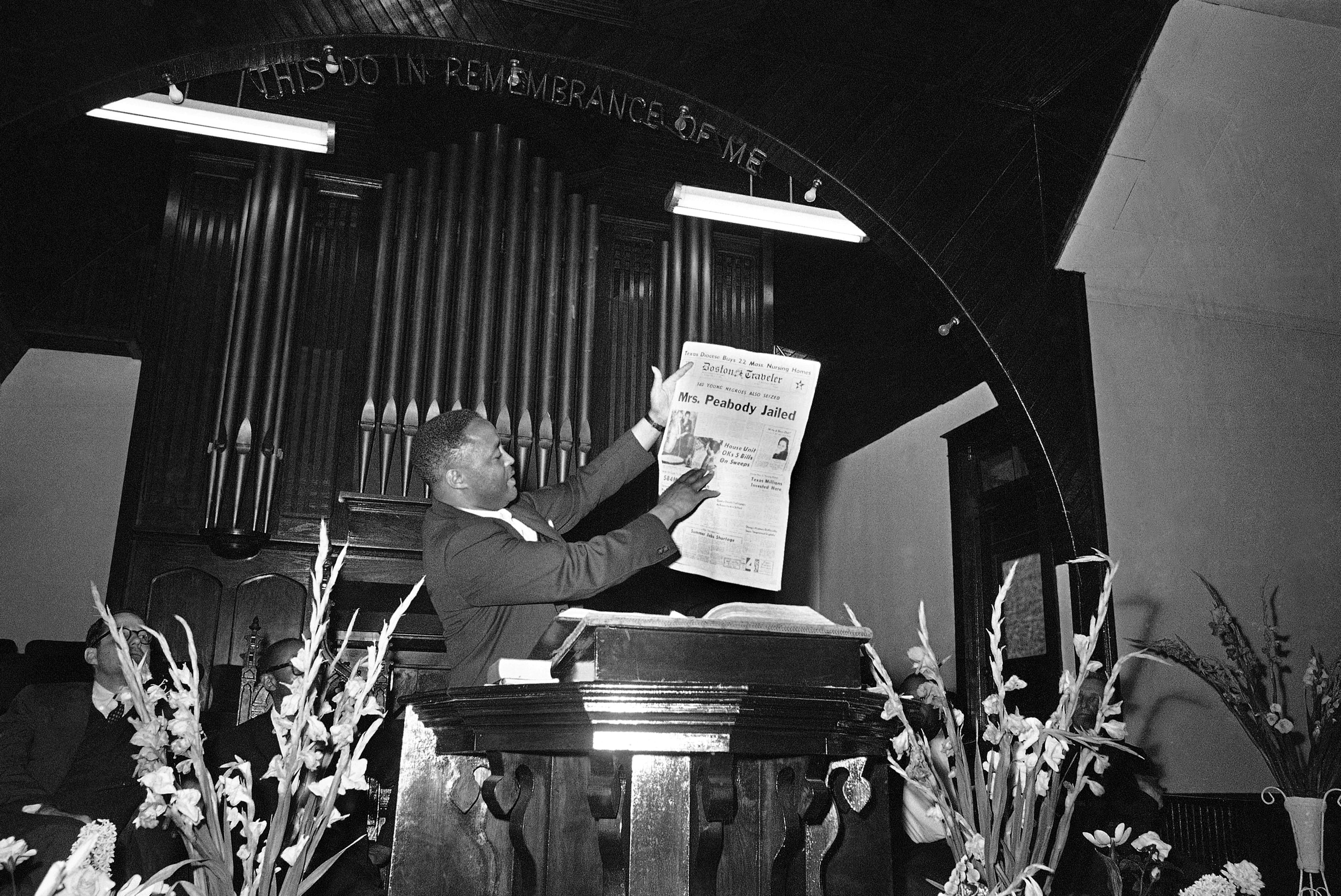 Integration leader Hosea Williams holds up Boston newspaper at rally in St. Augustine, Florida on April 1, 1964 as he calls for volunteers for new demonstrations. The headline refers to Mrs. Malcolm Peabody who was jailed. She is the mother of the governor of Massachusetts.