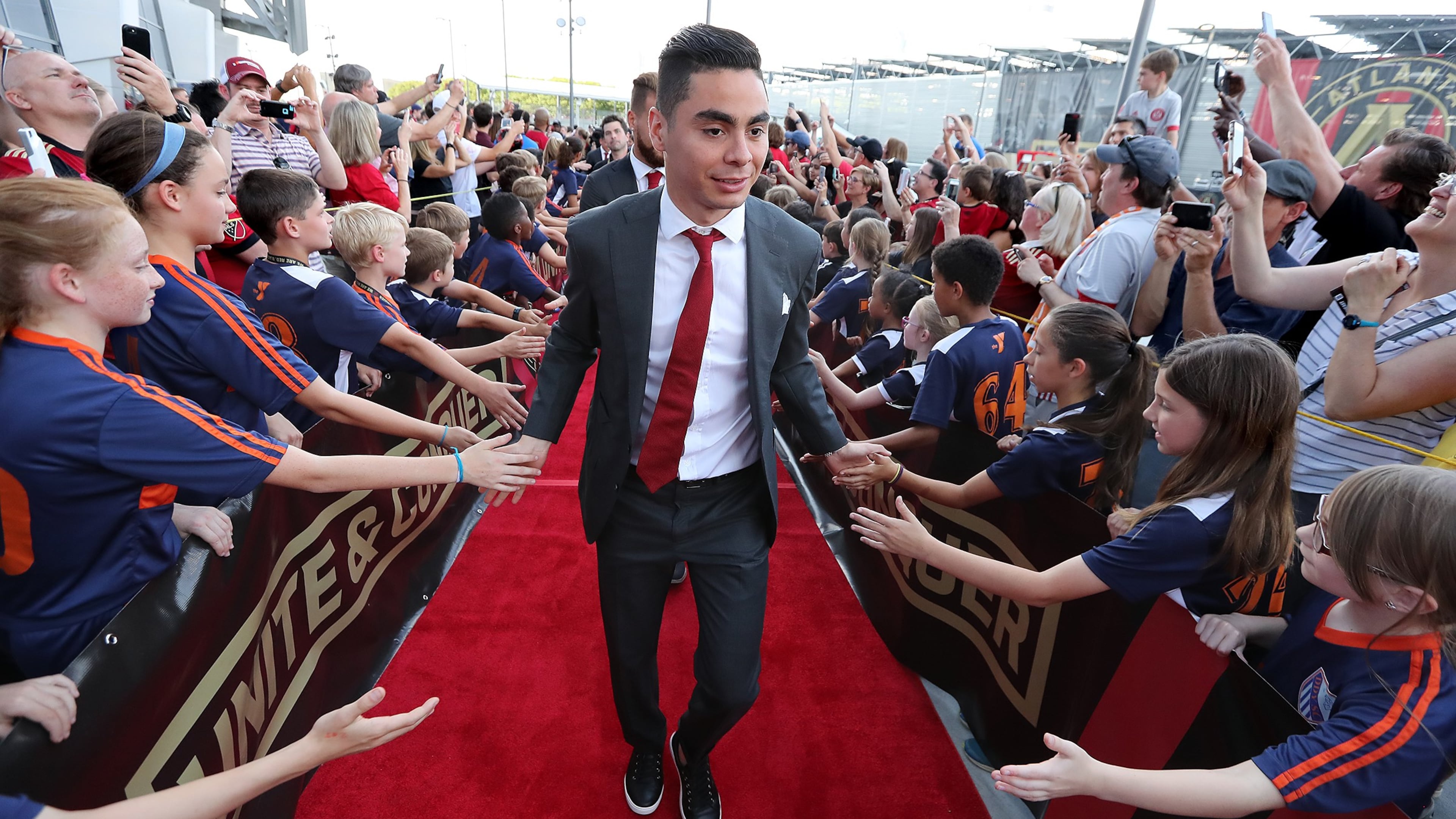 Atlanta United midfielder Miguel Almiron high fives fans during the team arrival at Mercedes-Benz Stadium to play Sporting Kansas City in a MLS soccer match on Wednesday, May 9, 2018, in Atlanta. Curtis Compton/ccompton@ajc.com