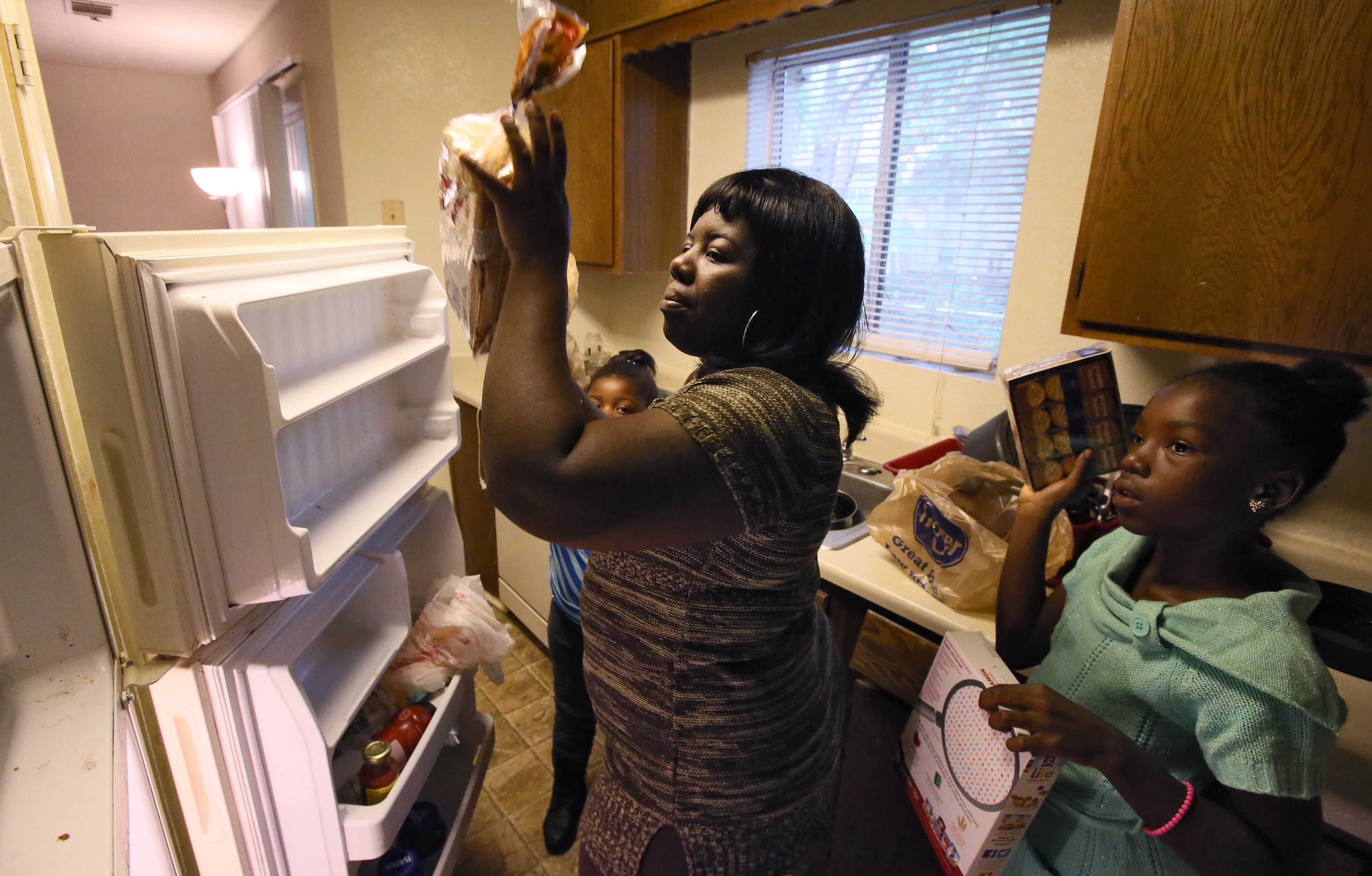 Mikyia Damous, 10, helps her mother, Lawanna Damous, unload groceries after a trip to Kroger. Lawanna is a single mom who drives nearly a half hour to the nearest Kroger to get fresh produce and meats for her family. Experts say food deserts weigh heavily on the state's chronic disease burden, costing it billions of dollars annually in diabetes care, treatment and management alone. BOB ANDRES / BANDRES@AJC.COM