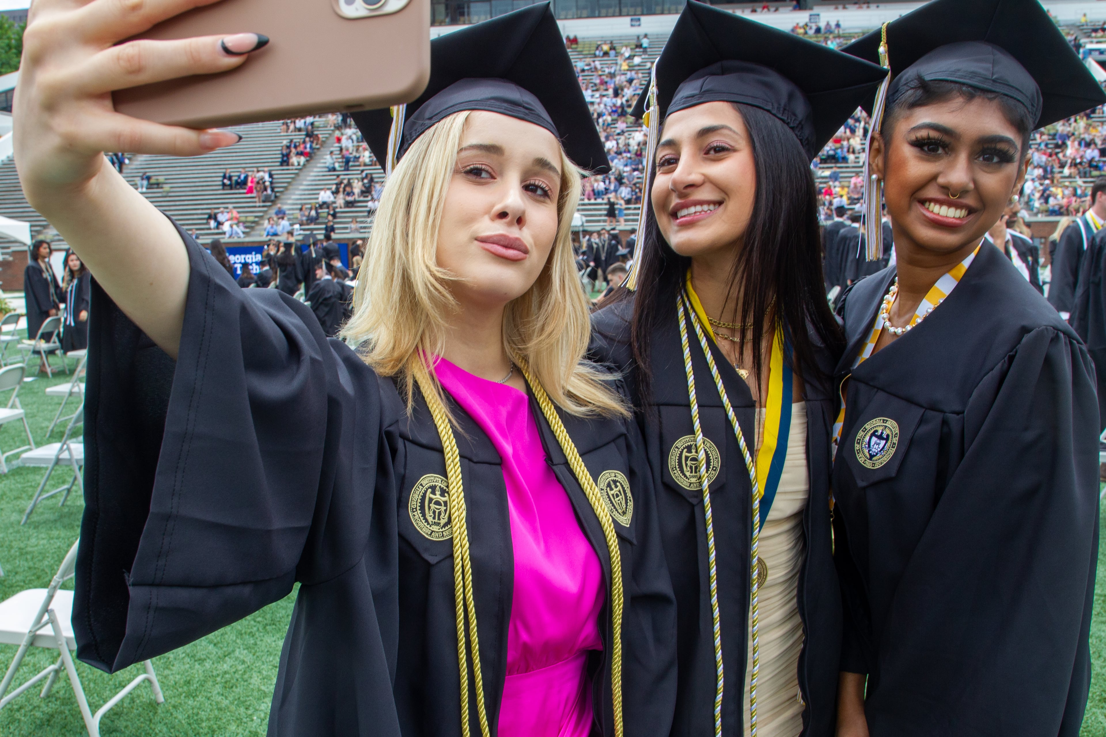 Lzgin Ozdas (left) takes a selfie with her friends before the start of the Georgia Institute of Technology's afternoon Commencement Ceremony at Bobby Dodd Stadium on Saturday, May 7, 2022. (Steve Schaefer / steve.schaefer@ajc.com)