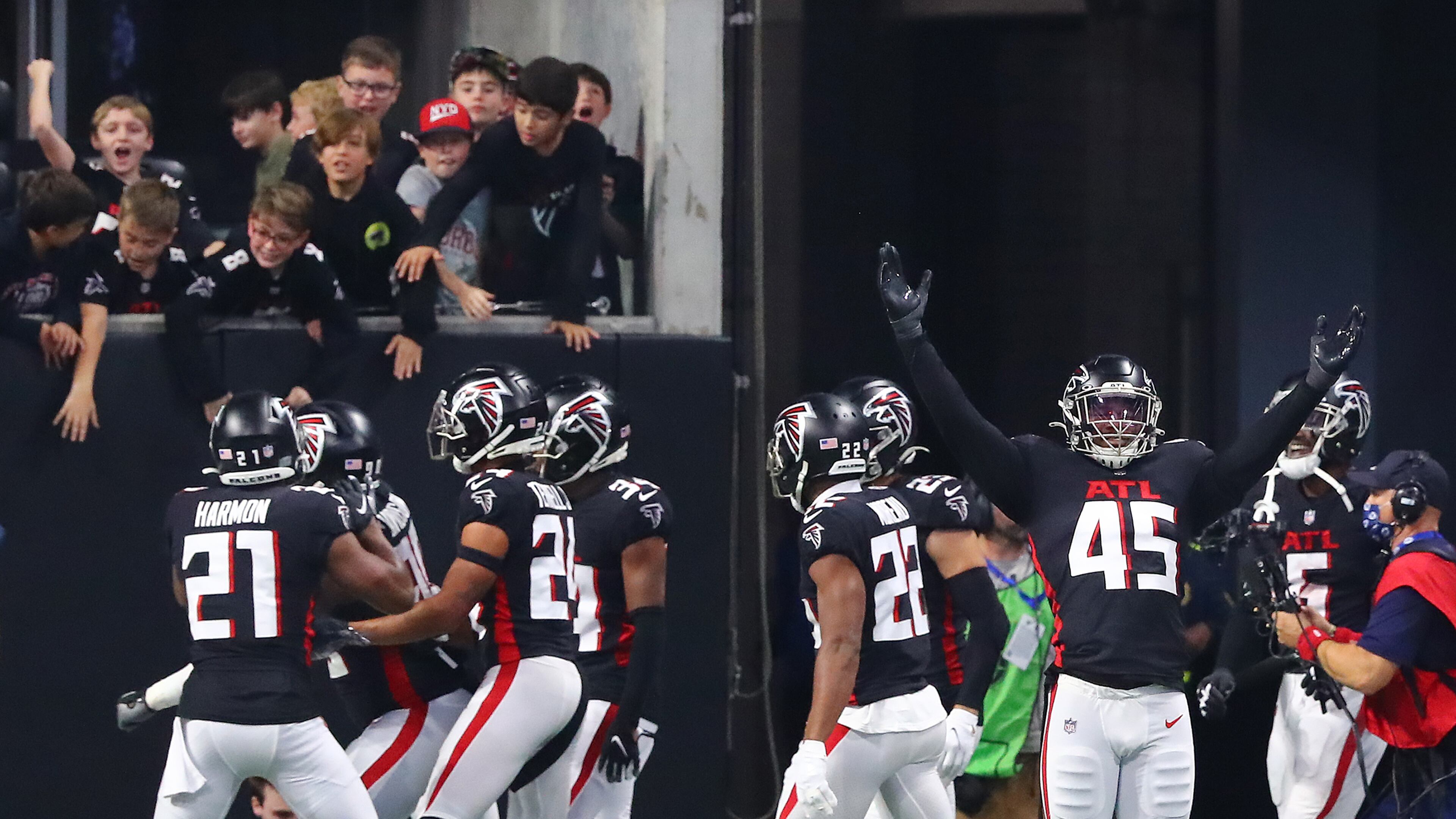 120521 Atlanta: Falcons linebacker Deion Jones (right) and teammates react after defensive lineman Marlon Davidson intercepts Buccaneers quarterback Tom Brady for a pick six at the end of the second quarter in a NFL football game on Sunday, Dec 5, 2021, in Atlanta. “Curtis Compton / Curtis.Compton@ajc.com”`
