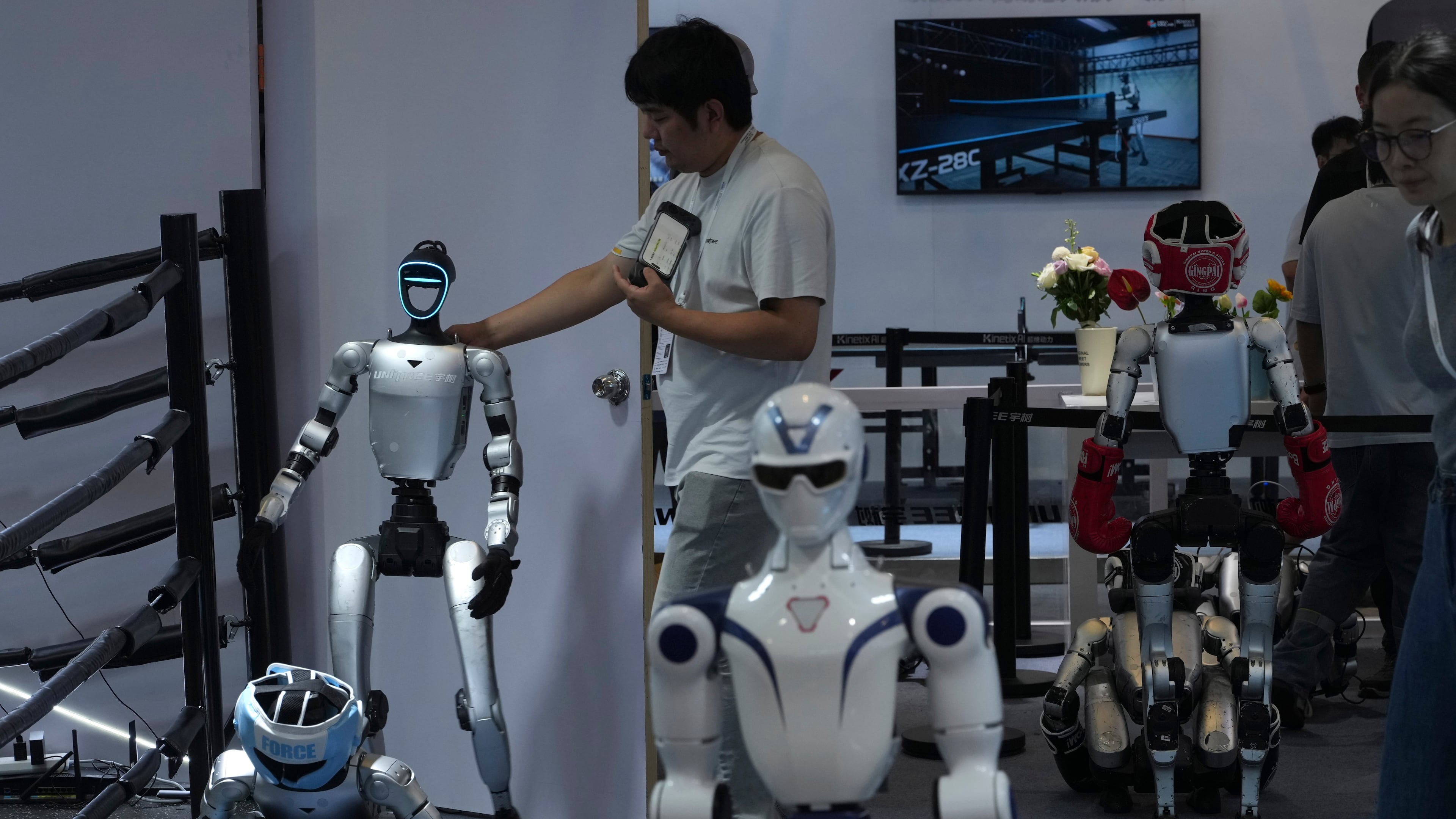 A worker gets a robot ready for demonstration at a booth for leading Chinese commercial humanoid robotics firm Unitree Robotics during the World AI Conference in Shanghai, China, on July 18, 2026. (AP Photo/Ng Han Guan)