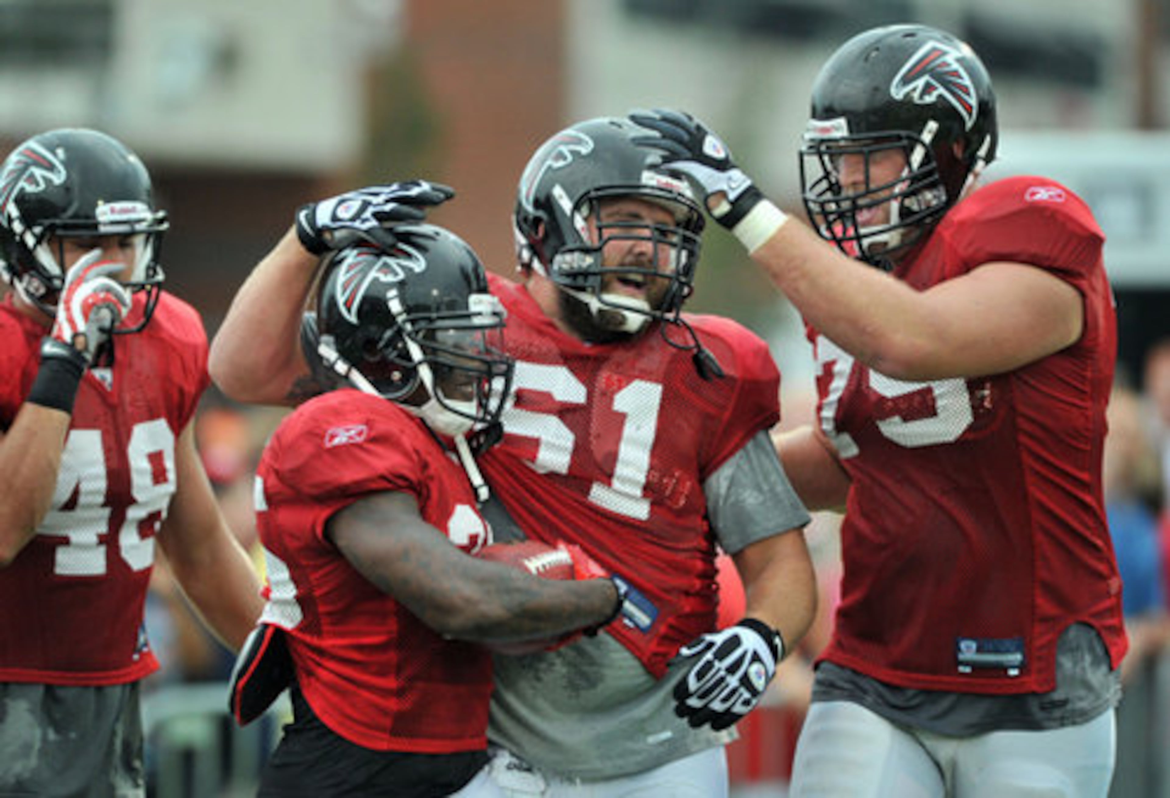 Atlanta Falcons's Antone Smith (second from left, 35) is congratulated by his teammates Joe Hawley (61) and Garrett Reynolds (75) during the Friday Night Lights at North Gwinnett High School in Suwanee.