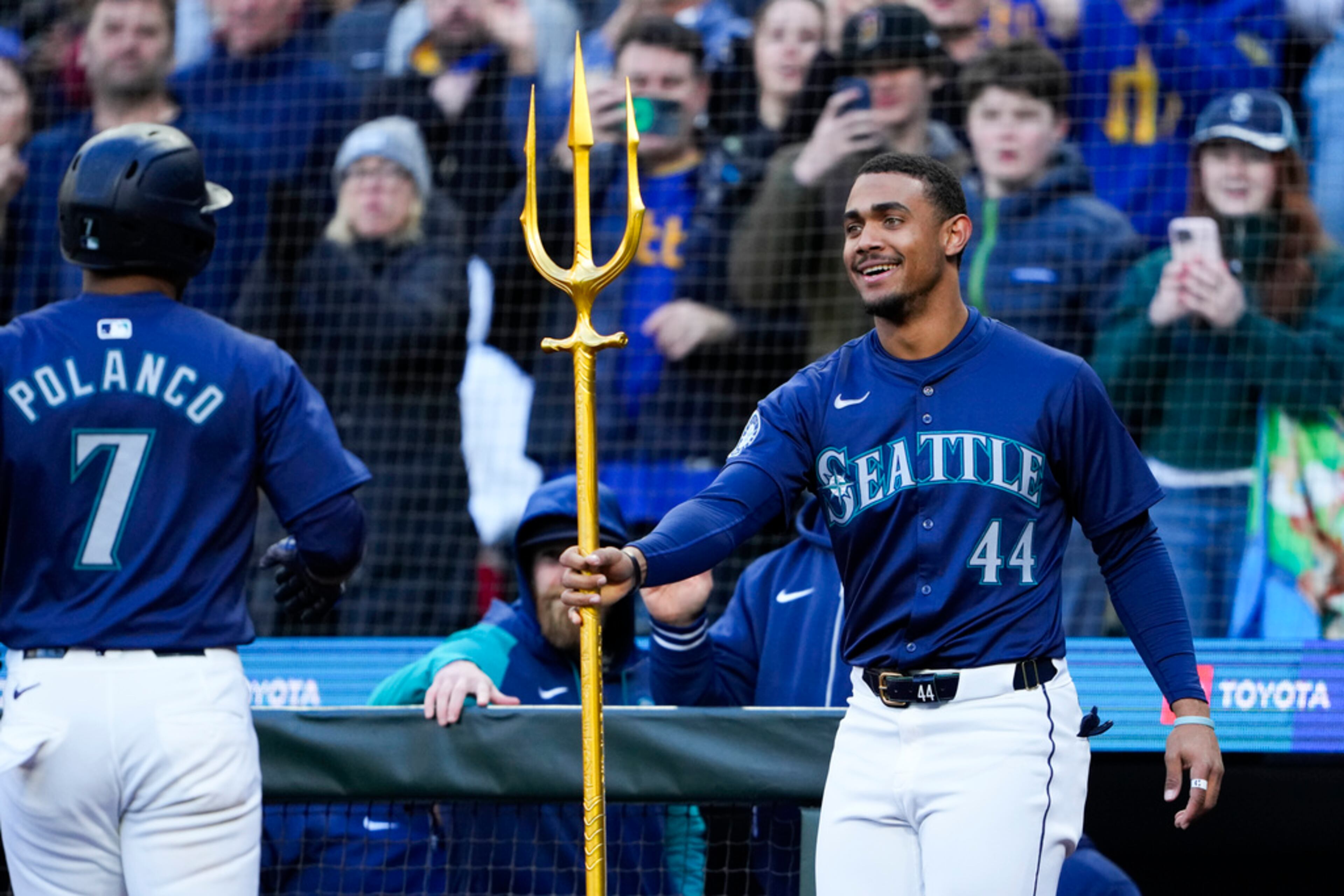 Seattle Mariners' Julio Rodríguez (44) hands a trident to Jorge Polanco (7) to celebrate Polanco's two-run home run against the Atlanta Braves during the third inning of a baseball game Tuesday, April 30, 2024, in Seattle. (AP Photo/Lindsey Wasson)