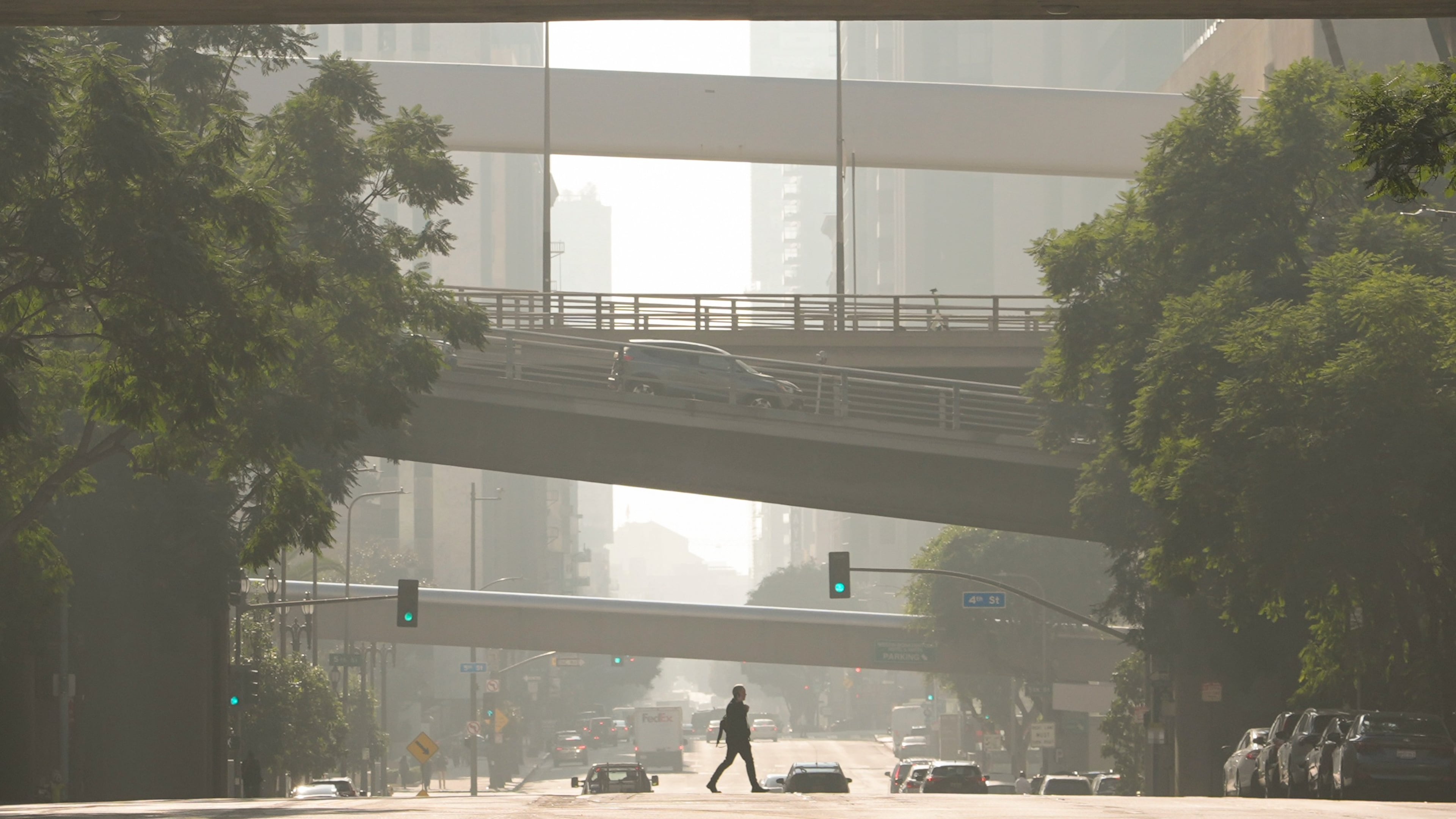 FILE - A person crosses a street as pollution fills the air, Dec. 4, 2024, in Los Angeles. (AP Photo/Andy Bao, File)