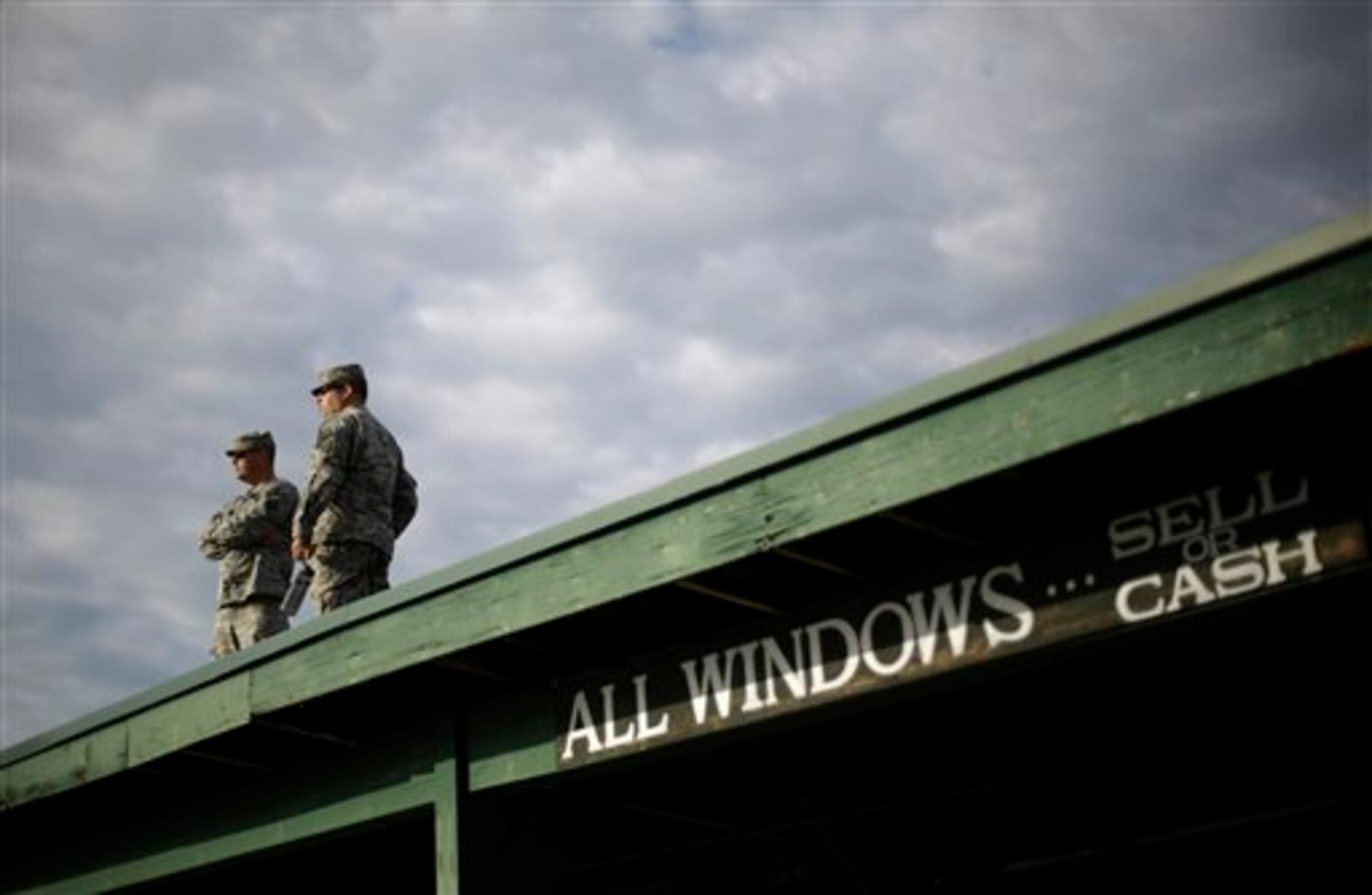 Military personal look over the track at Churchill Downs Saturday, May 3, 2014, in Louisville, Ky. (AP Photo/David Goldman)