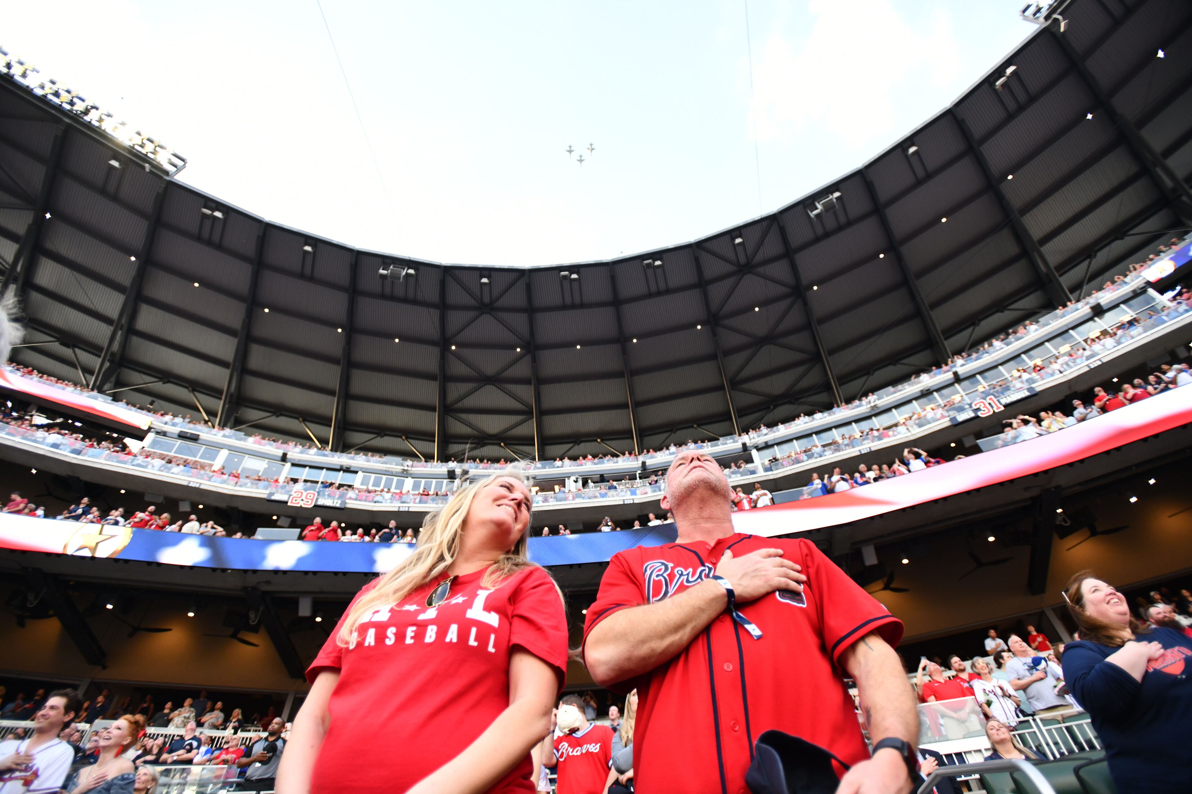 Atlanta Braves fans watch a fly over before Atlanta Braves’s home opener baseball game against Miami Marlins at Truist Park, Friday, April 4, 2025, in Atlanta. (Hyosub Shin / AJC)