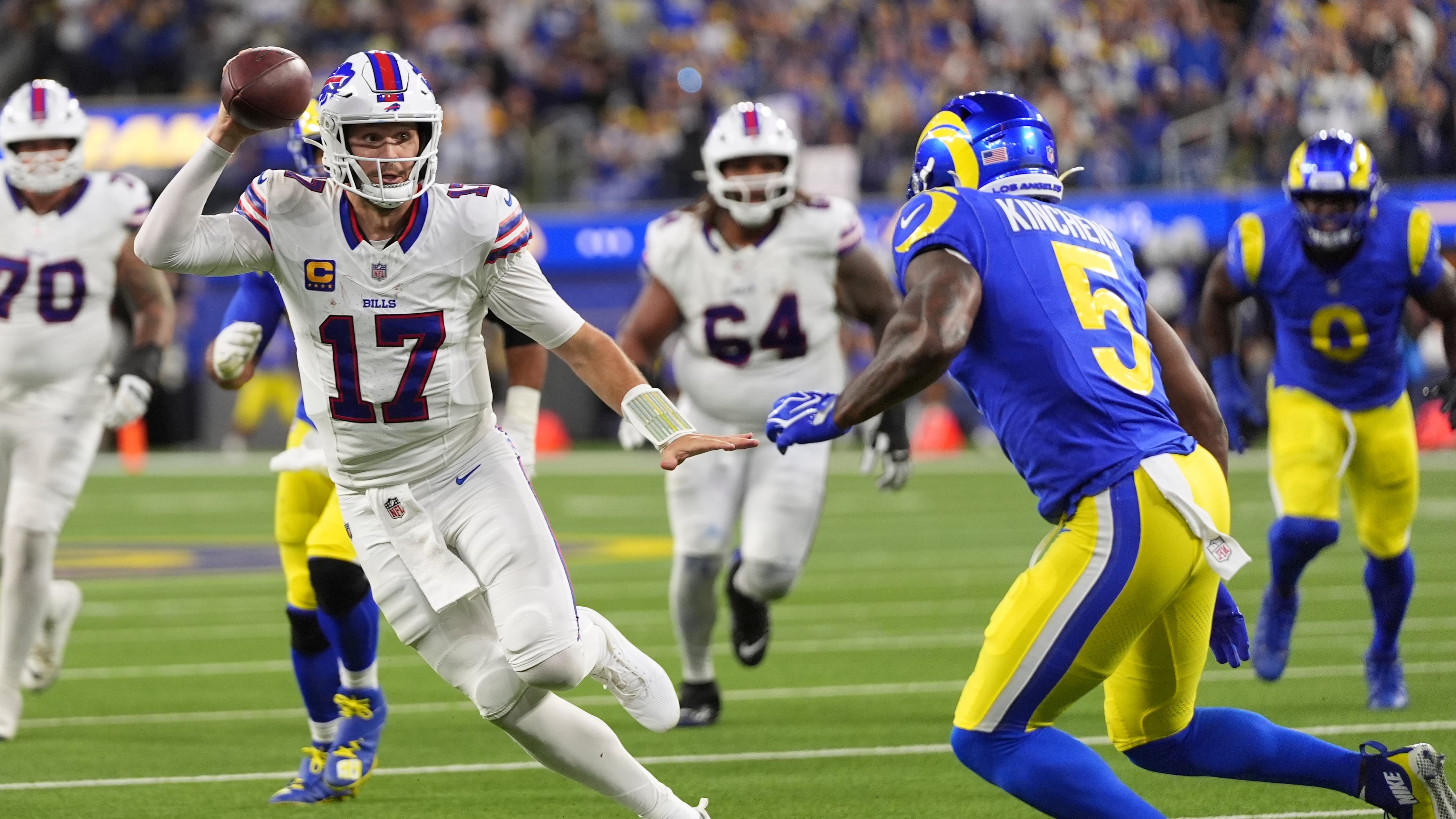 Buffalo Bills quarterback Josh Allen, left, runs the ball as Los Angeles Rams safety Kamren Kinchens defends during the second half of an NFL football game, Monday, Oct. 12, 2026, in Inglewood, Calif. (AP Photo/Gregory Bull)