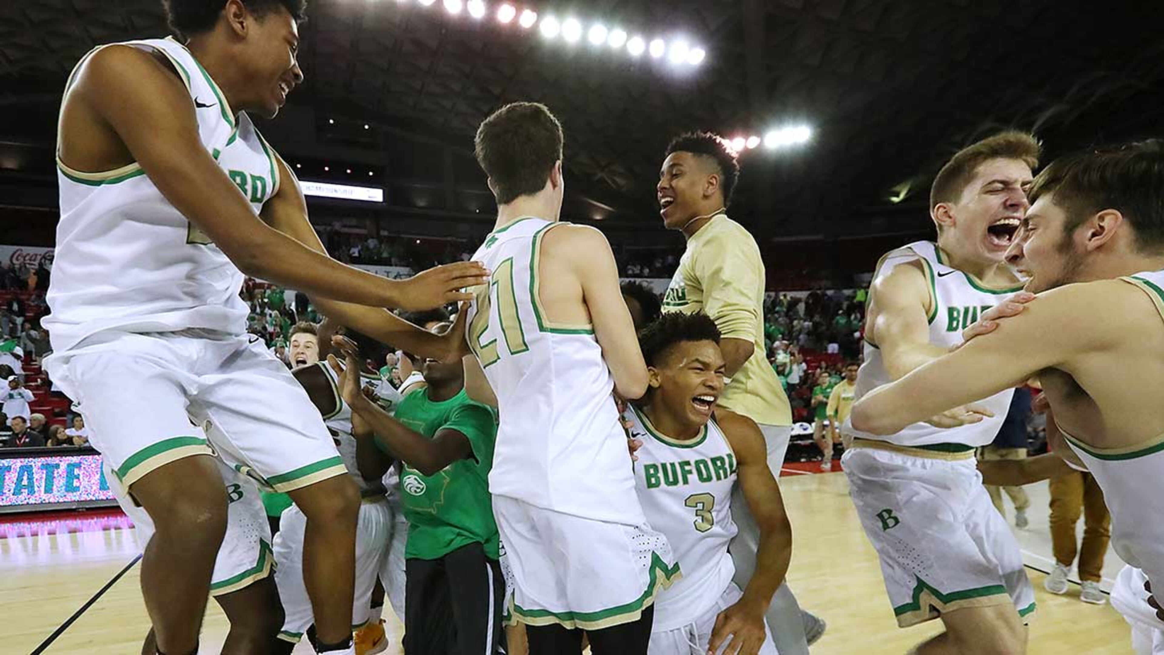The Buford Wolves charge the court as time expires celebrating a 75-61 victory over the Cedar Shoals Jaguars in their 5A boys GHSA State Basketball Championship game Wednesday.