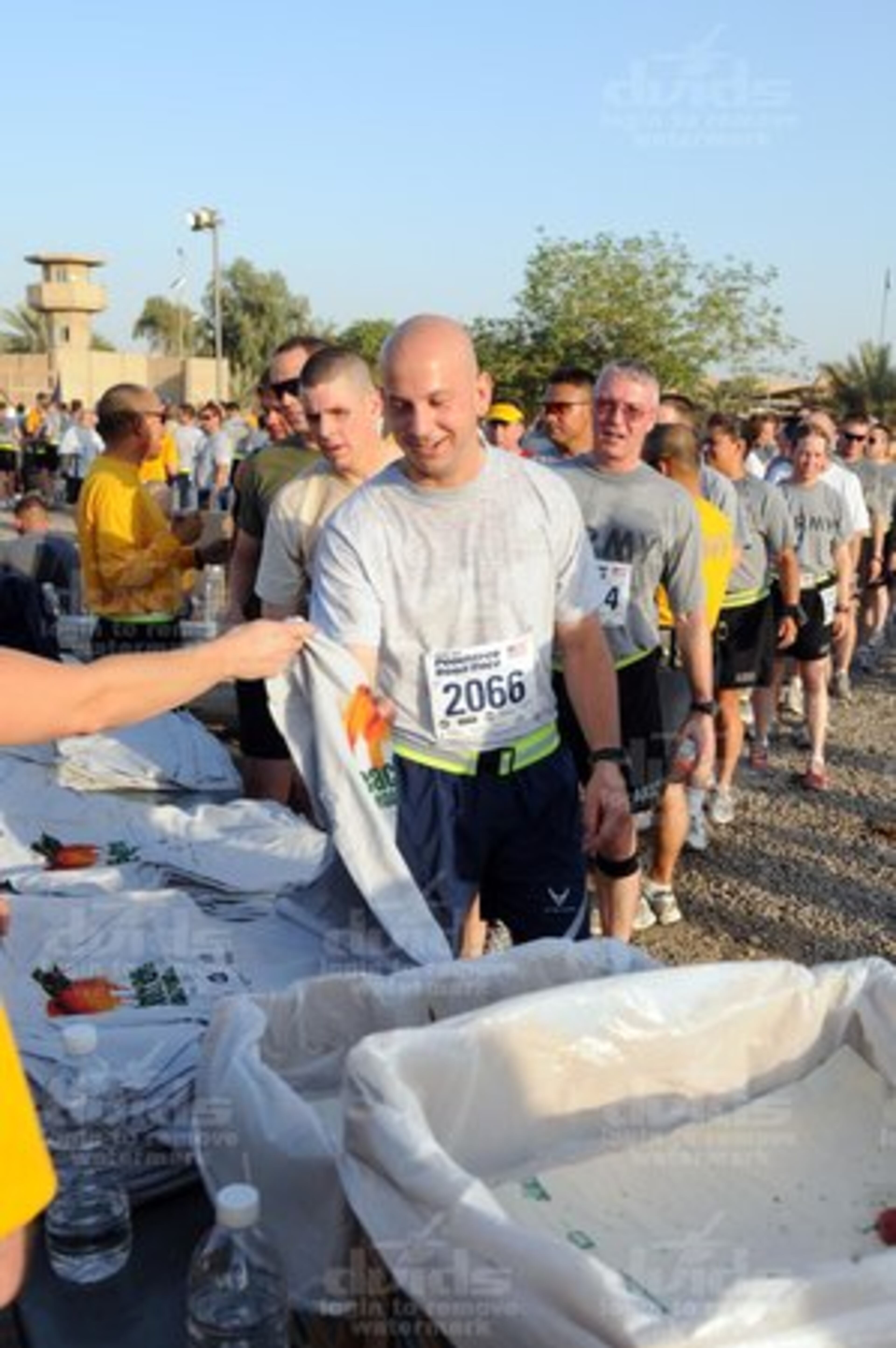 AJC Peachtree Road Race runners in Baghdad receive their T-shirts after the race.