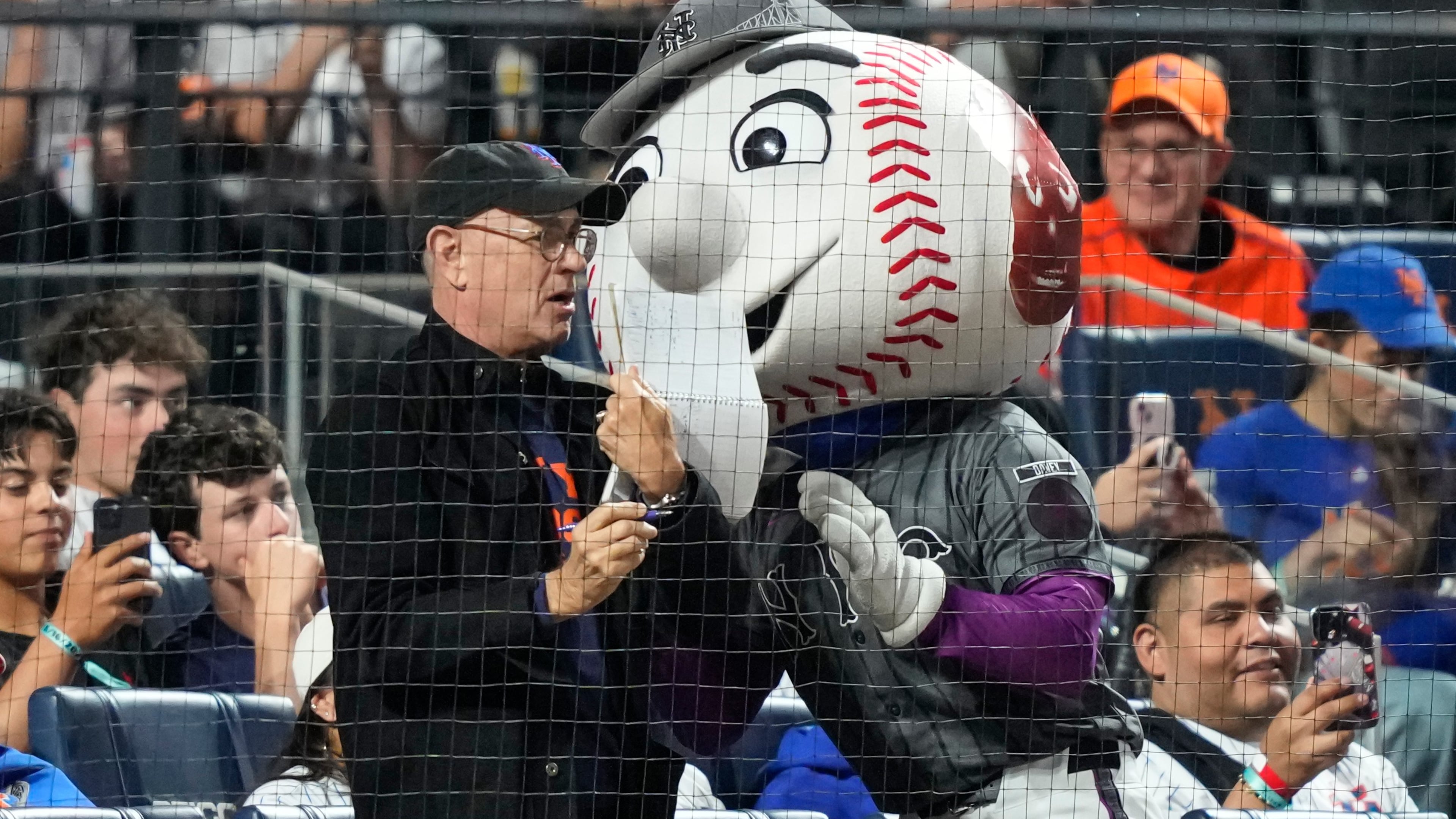 Actor/filmmaker Tom Hanks, center left, stands with Mr. Met, center right, during the sixth inning of a baseball game between the New York Mets and the New York Yankees, Saturday, May 16, 2026, in New York. (AP Photo/Yuki Iwamura)