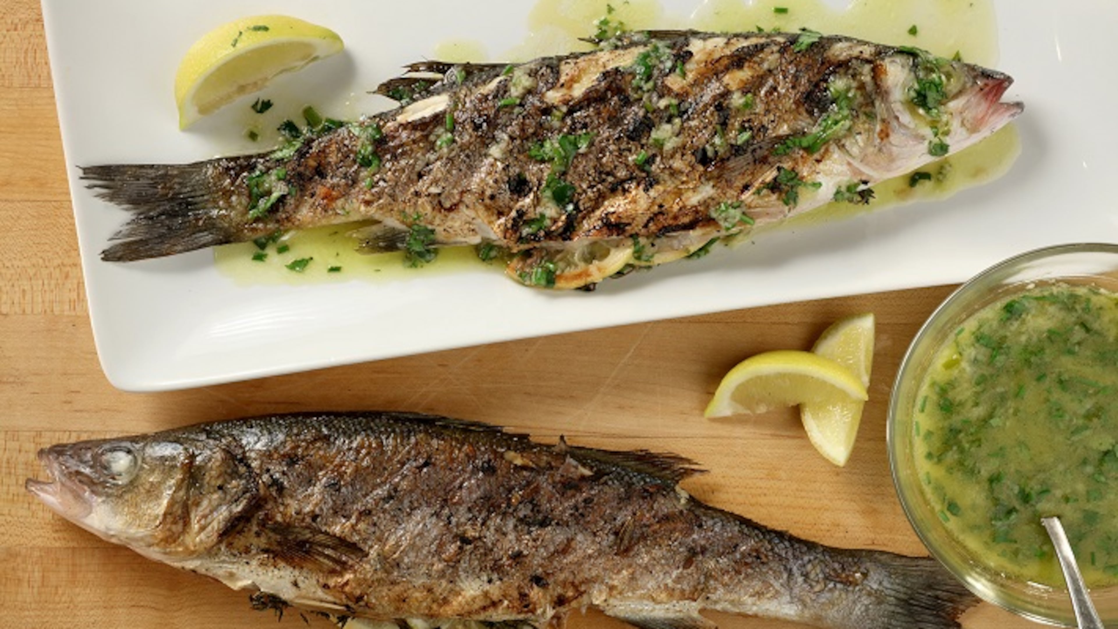 For the herb-grilled Mediterranean sea bass recipe, the fish are drizzled after grilling with a lemon, ginger and chive finishing sauce. (Michael Tercha/Chicago Tribune/TNS)