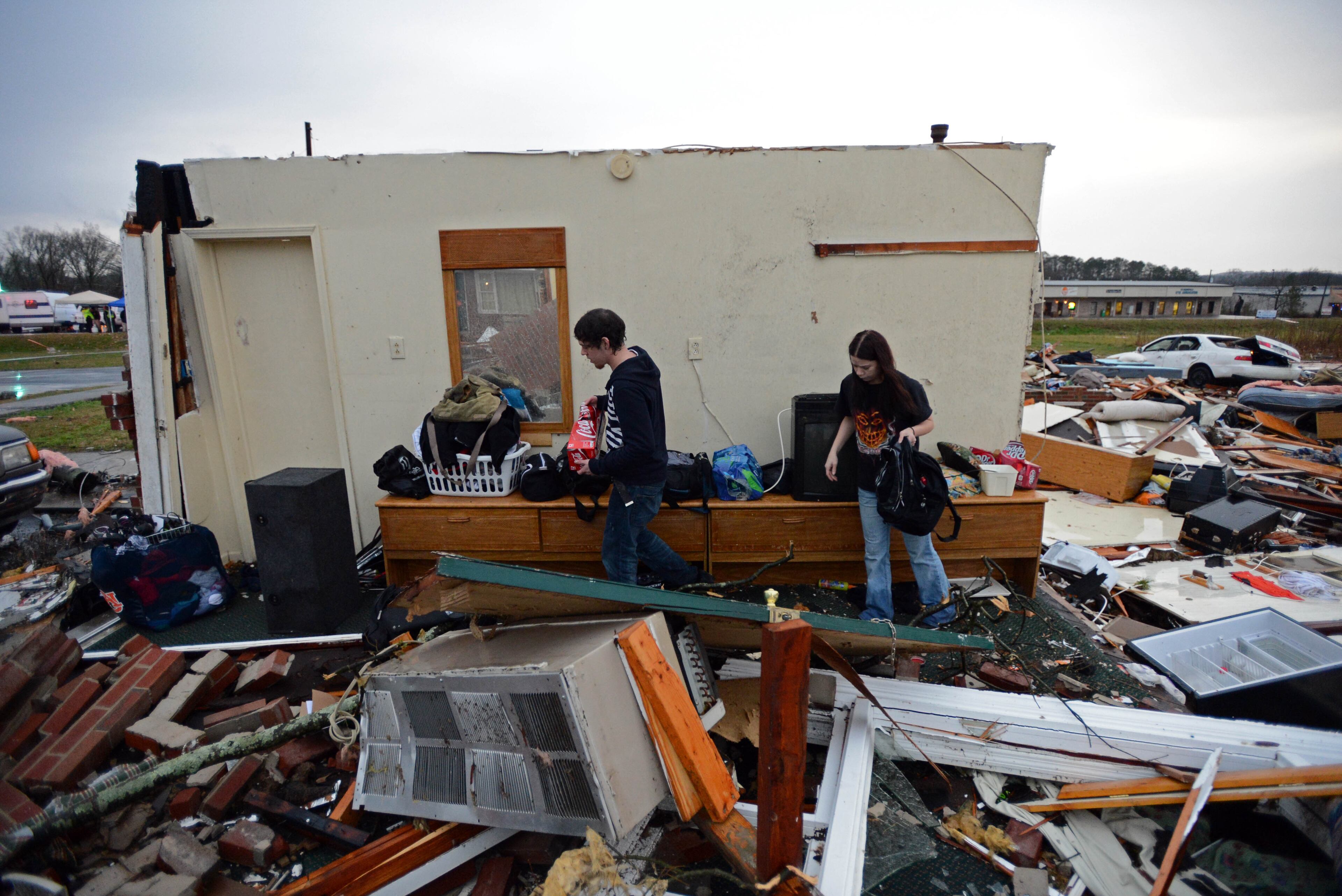 Miguel Fuentes (left) and his girlfriend Iva Collins save their belongs at Relax Inn on Joe Frank Harris Parkway in Adairsville on Wednesday. Collins said she felt lucky she was not in her room when the tornado hit.