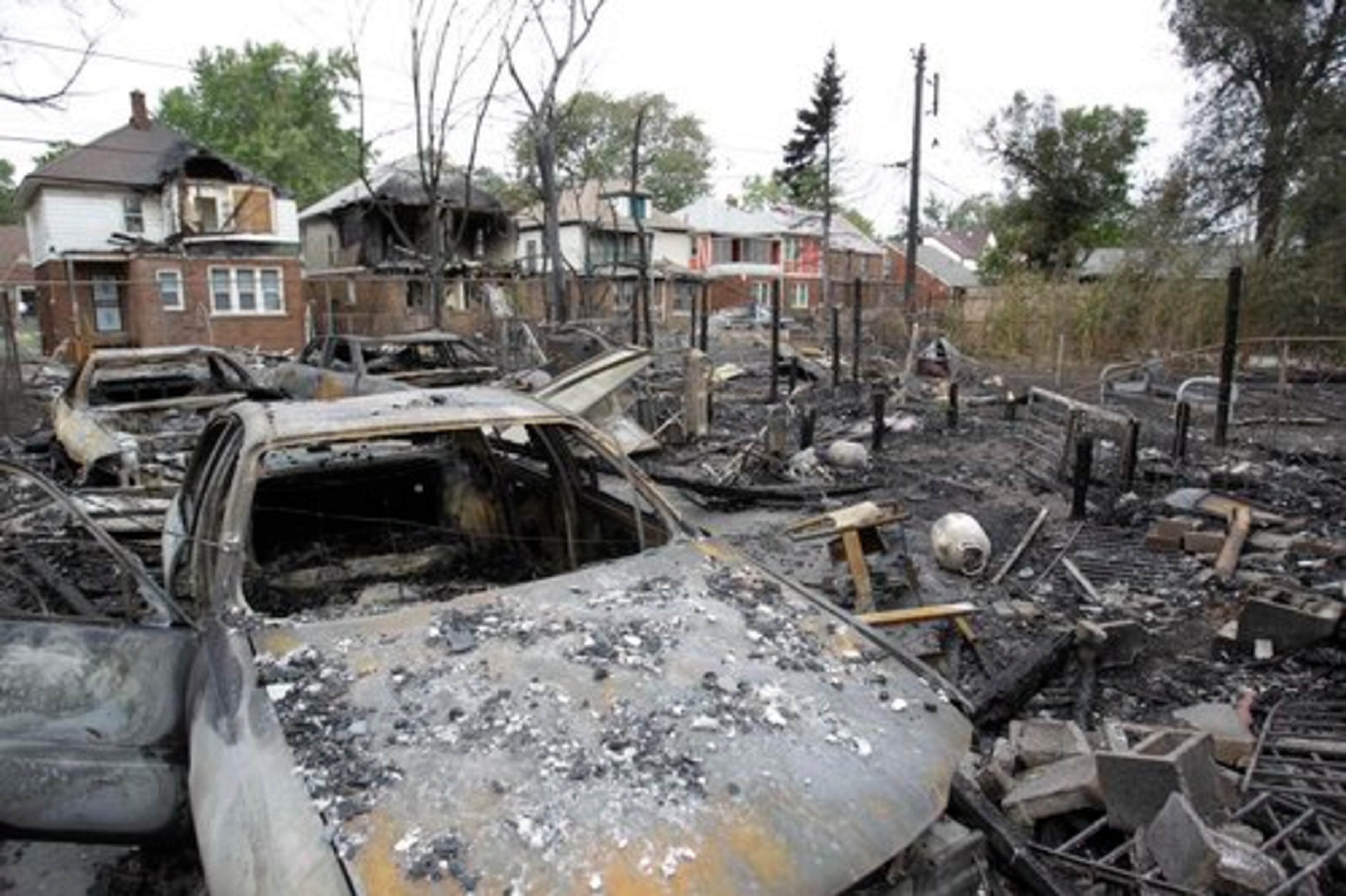 Burned cars and property are seen on the west side of Detroit on Wednesday, Sept. 8, 2010. Fire officials say flames have swept through at least two dozen homes in the Motor City, fanned by strong winds that toppled power lines across the city.