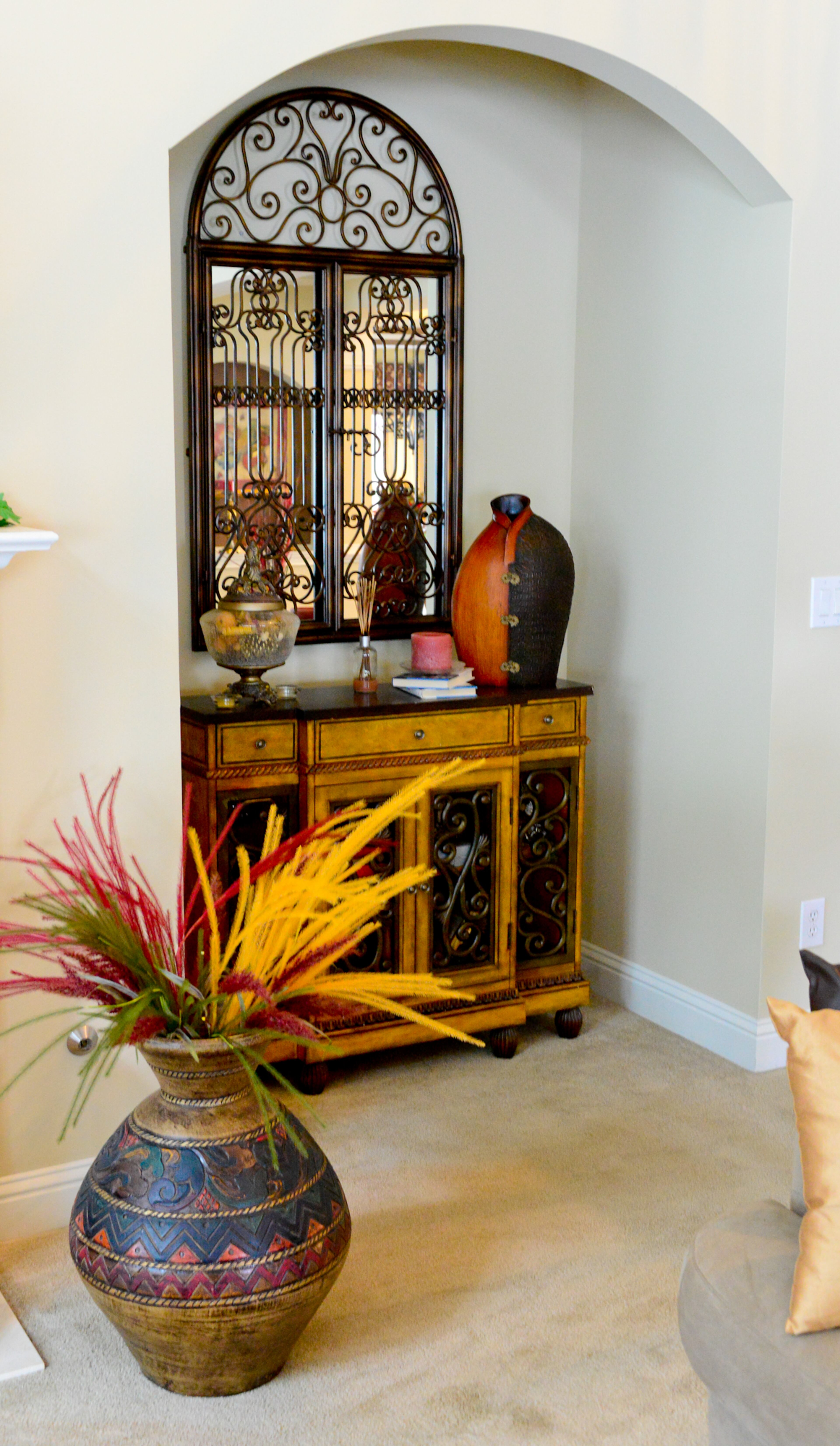 One of the family room niches features a chest from Kirkland's, which perfectly matches the mirror with the scrollwork from Rooms To Go. The urn is from Pier 1 Imports.