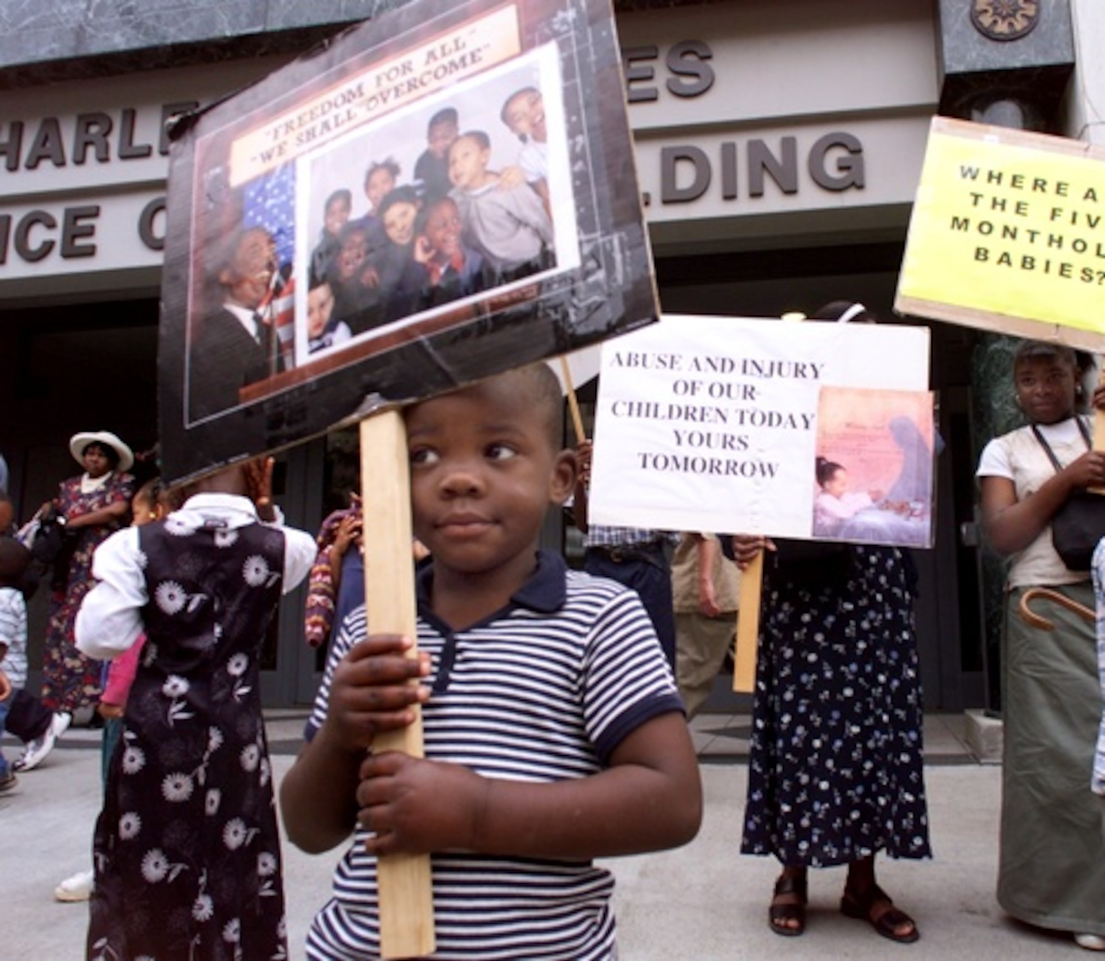 After the forced separation, church members protested to have their children released ffrom state custody. Here, 3-year-old church member, Charles Ogletree, holds a freedom sign with MLK Jr. on it. (JOHN SPINK/JSPINK@AJC.COM)