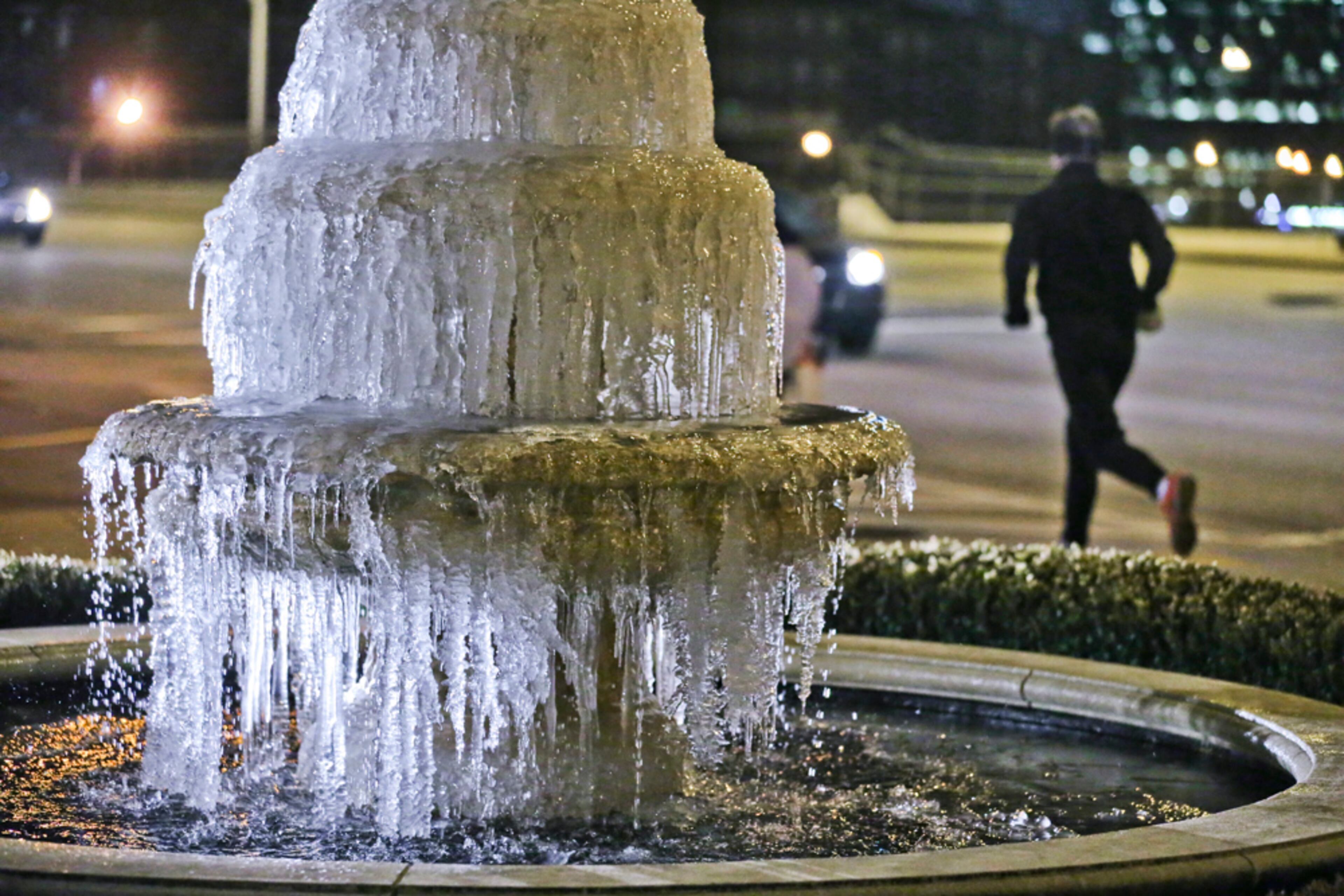 ICED OVER--Jan. 23, 2014 Atlanta: A runners passes by the frozen fountain at Deering Road and Peachtree Street in front of the Aveda Institute in Atlanta Jan. 23, 2014 as Thursday’s wake-up temperatures weren’t quite as cold as on Wednesday morning, but forecasters said a reinforcing blast of Arctic air will push the mercury into the low teens or lower again by early Friday. All of metro Atlanta is under a wind chill advisory for dangerously low sub-zero wind chills through 10 a.m. Friday along and north of a line from LaGrange to Gainesville, is calling for wind chills as low as -10 degrees. Channel 2 meteorologist Karen Minton said lows by early Friday will be around 12 degrees in the city, and highs Friday will only be around the freezing mark. Minton’s forecast for the weekend calls for sunny skies and warmer afternoon temperatures. Saturday’s morning lows around 20 will be followed by highs in the upper 40s, and on Sunday, the mercury should reach the low 50s after starting out in the upper 20s. Temperatures across metro Atlanta at 6 a.m. Thursday ranged from 19 in Peachtree City, 21 in Marietta and 22 in Dunwoody to 25 at Hartsfield-Jackson International Airport. Atlanta’s normal low for the date is 34, the normal high 53. JOHN SPINK/JSPINK@AJC.COM