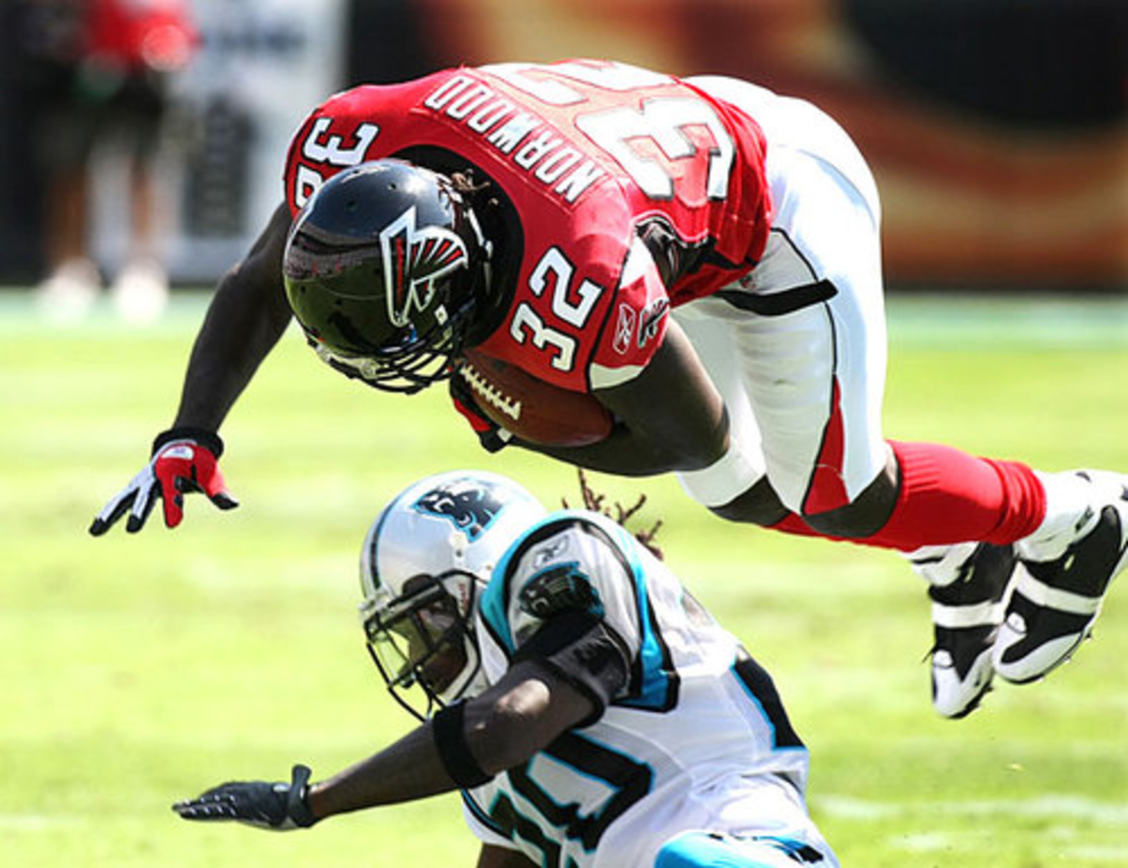 Falcons running back Jerious Norwood is upended by Panthers linebacker James Anderson.