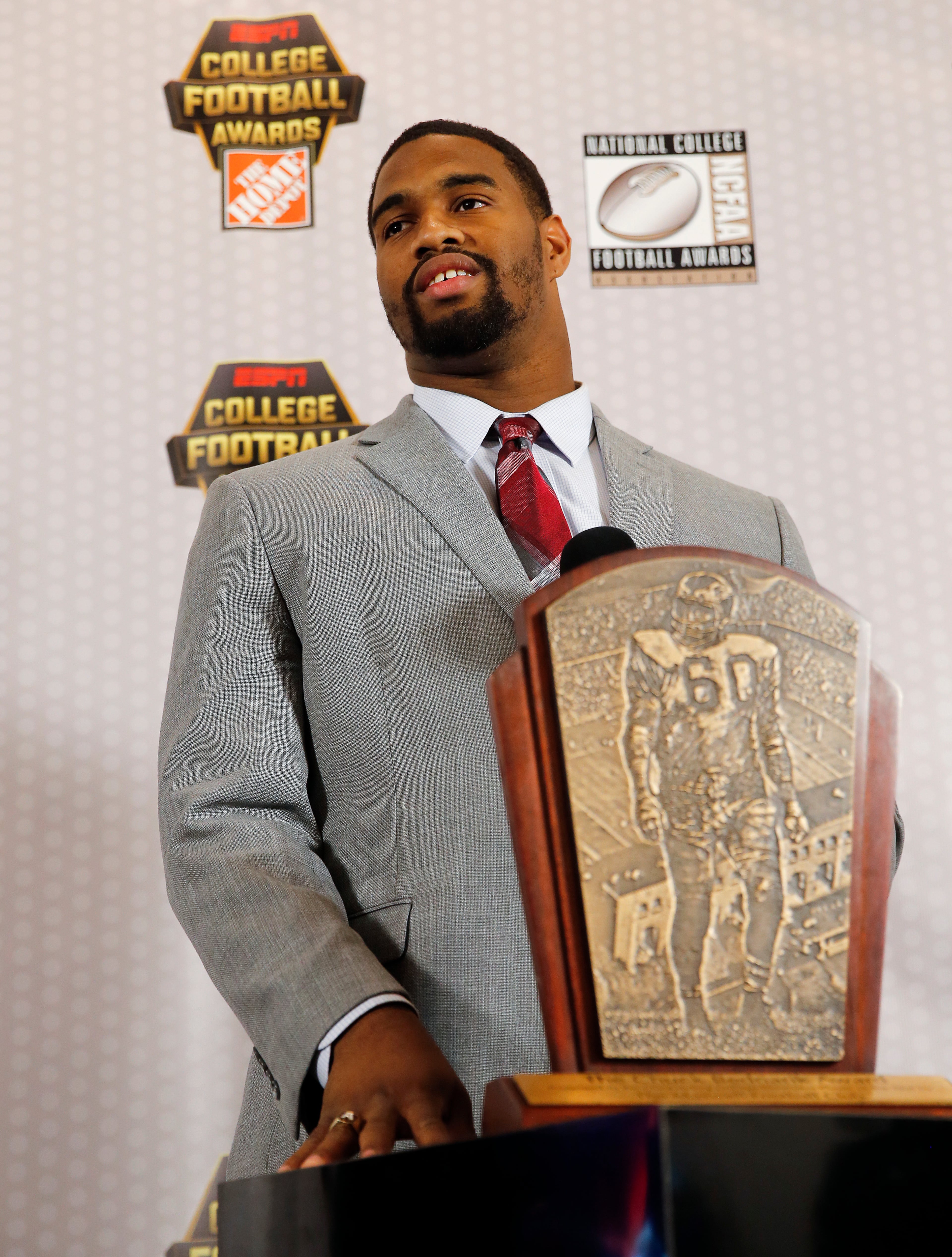Alabama's Jonathan Allen stands behind the Chuck Bednarik Award for College Defensive Player of the Year as he speaks to reporters Thursday, Dec. 8, 2016, in Atlanta. (AP Photo/John Bazemore)