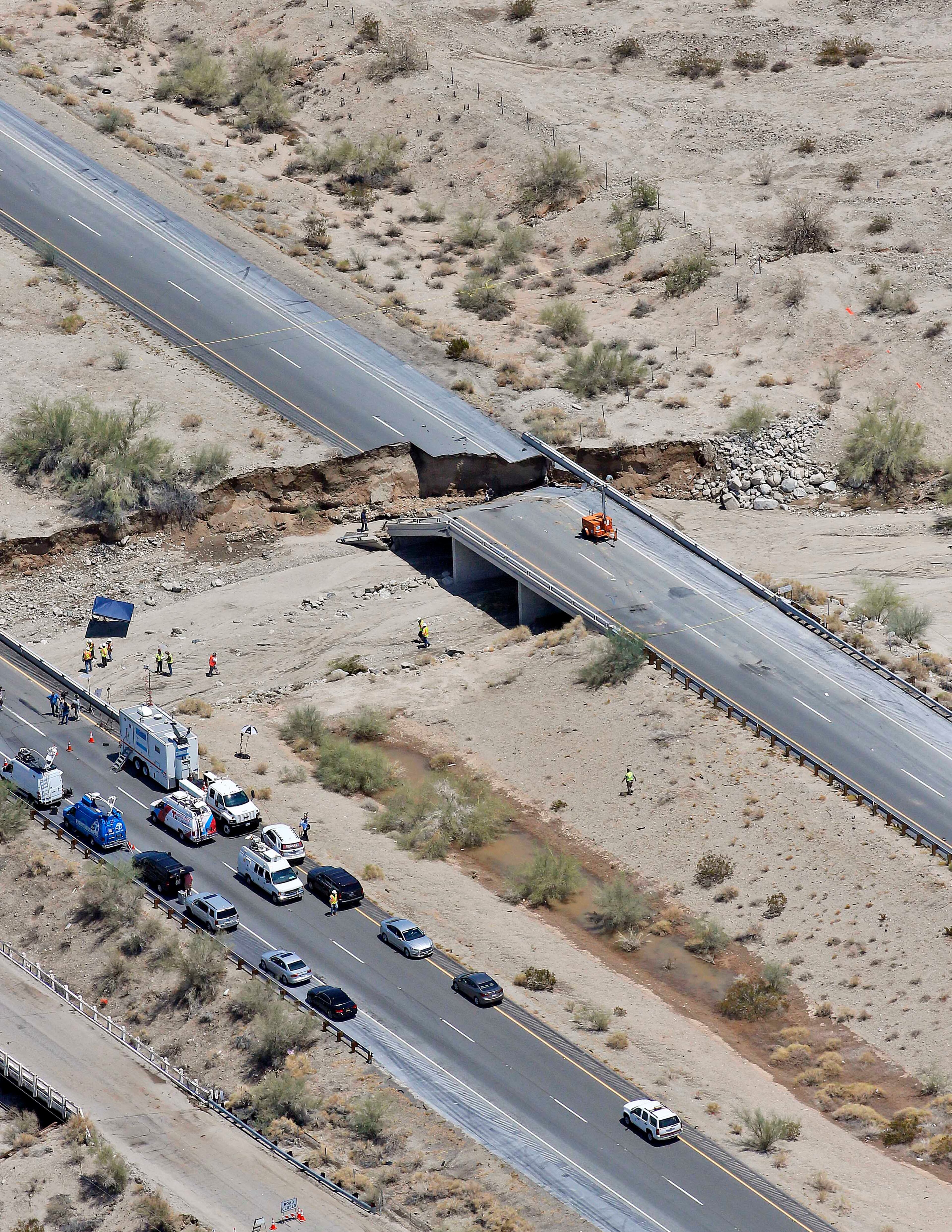 This aerial photo shows the collapsed elevated section of Interstate 10, Monday, July 20, 2015, in Desert Center, Calif. All traffic along one of the major highways connecting California and Arizona was blocked indefinitely when the bridge over a desert wash collapsed during a major storm, and the roadway in the opposite direction sustained severe damage. (AP Photo/Matt York)