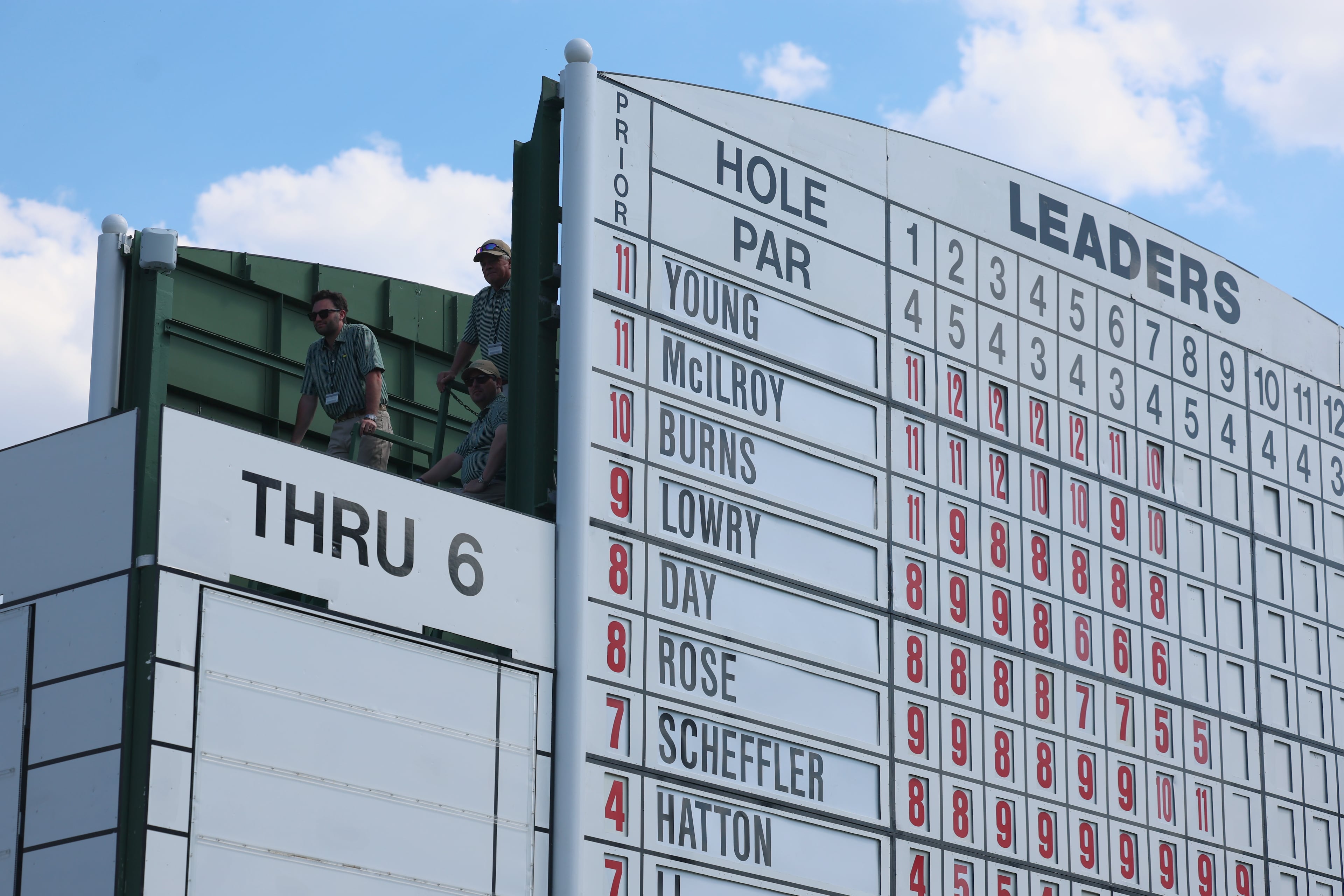 Scoreboard workers watch Cameron Young and Rory McIlroy tee off on eighth hole during final round of the Masters, at Augusta National Golf Club, Sunday, April 12, 2026, in Augusta, GA (Jason Getz/AJC)