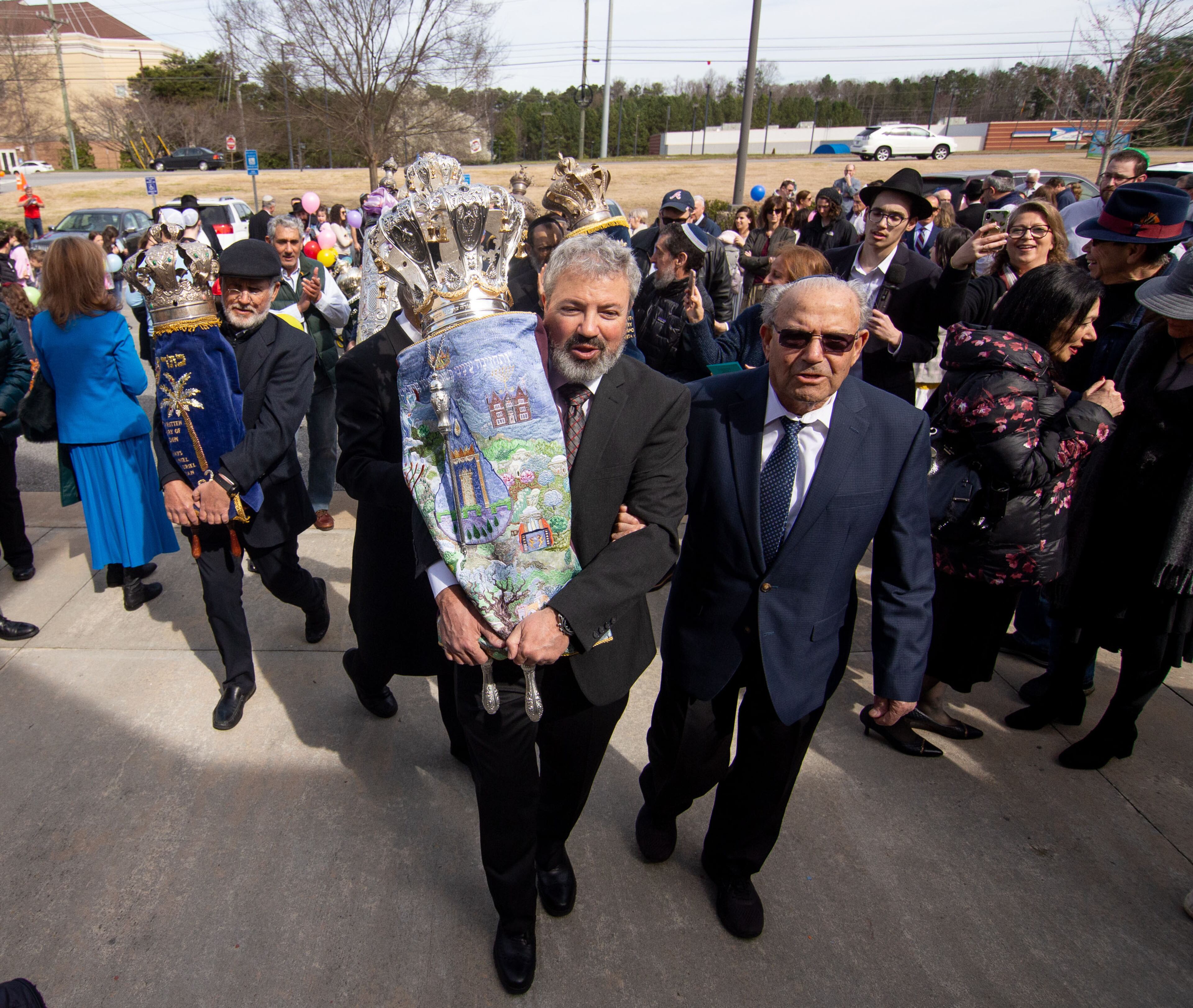 Eyal Postelnik carries the historic Torah scroll back into Chabad of Cobb after the parade celebrating the Torah scroll's completion Sunday, in Marietta March 8, 2020. STEVE SCHAEFER / SPECIAL TO THE AJC