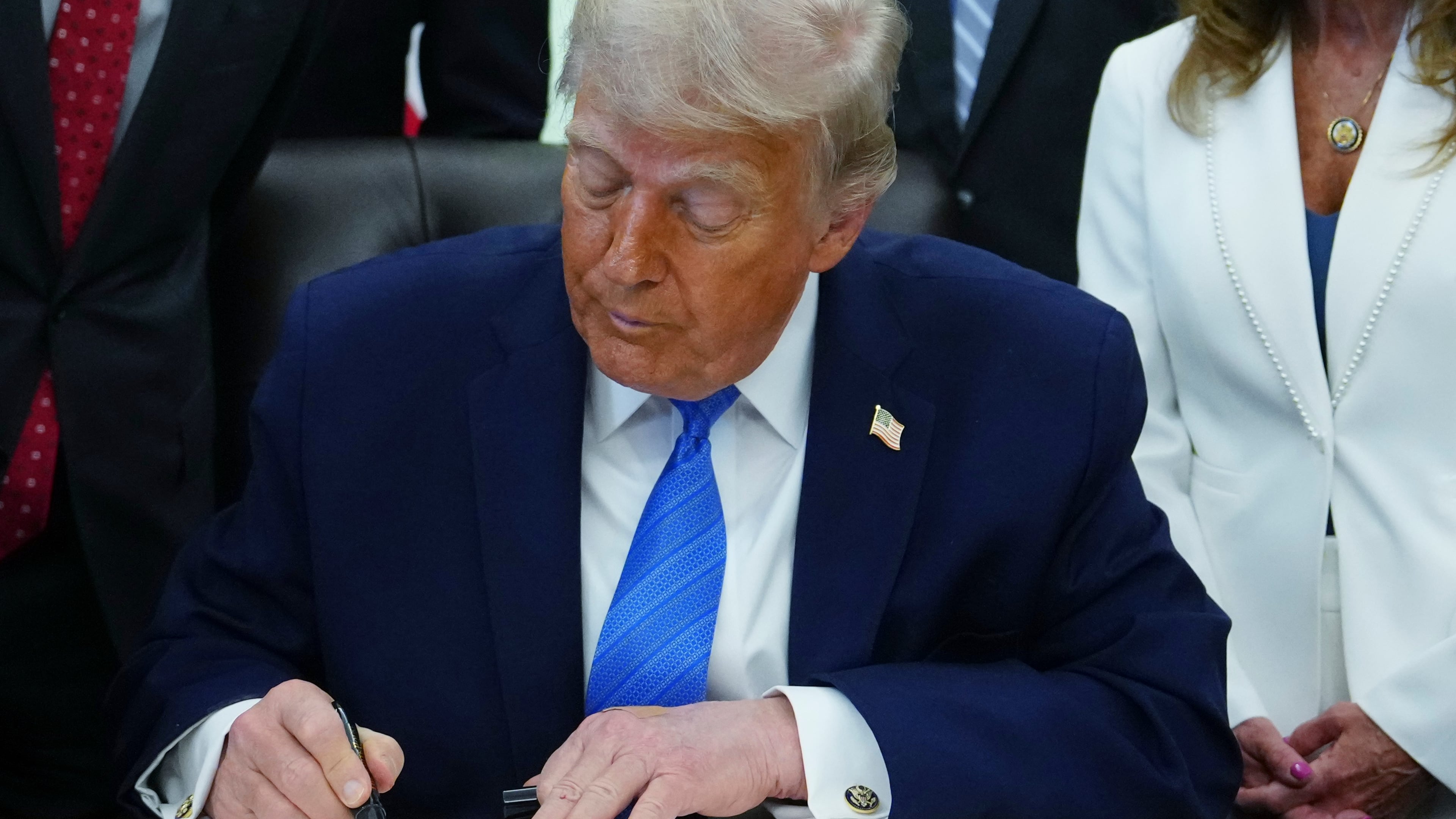President Donald Trump signs a bill funding immigration enforcement in the Oval Office of the White House, Wednesday, June 10, 2026, in Washington. (AP Photo/Julia Demaree Nikhinson)