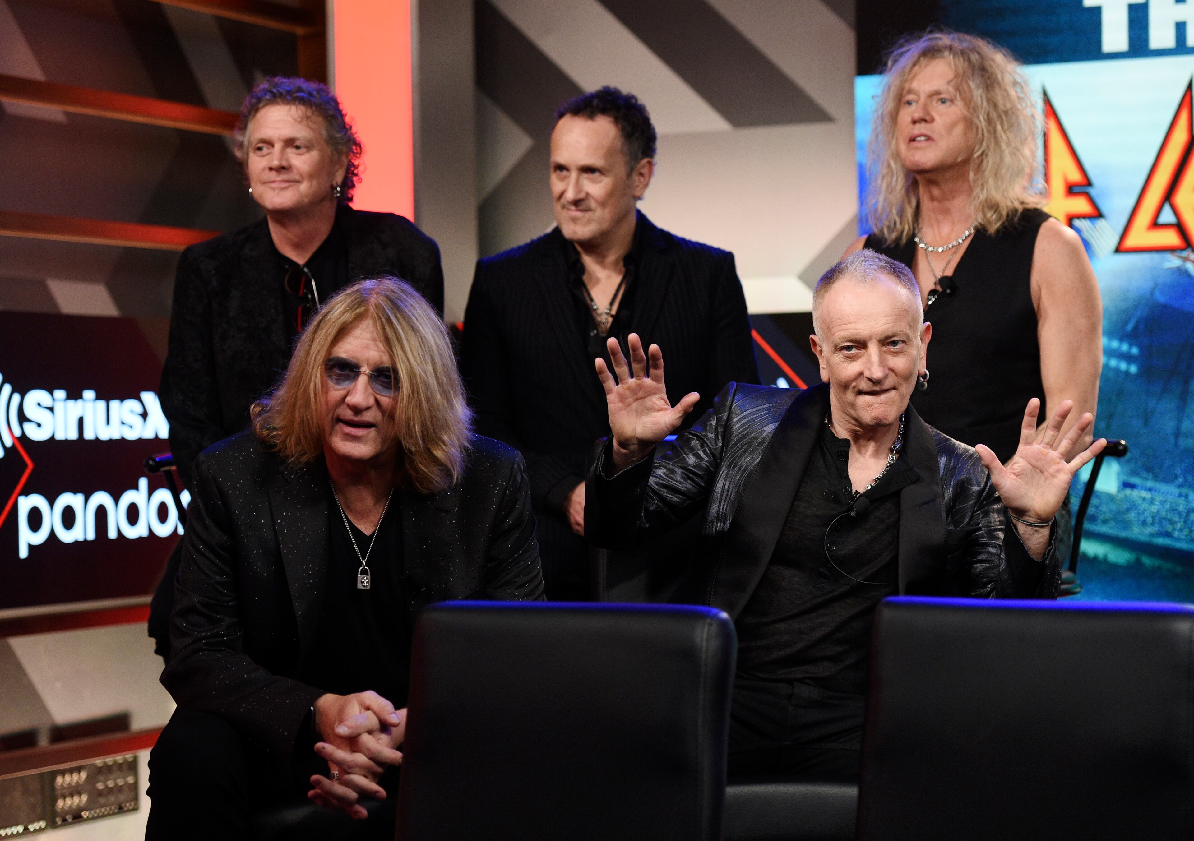 Rick Allen, from left, Joe Elliott, Vivian Campbell, Phil Collen and Rick Savage of Def Leppard sit for a a news conference to announce The Stadium Tour 2020 featuring Def Leppard, Poison and Motley Crue, at the SiriusXM offices, Wednesday, Dec. 4, 2019, in Los Angeles. (AP Photo/Chris Pizzello)