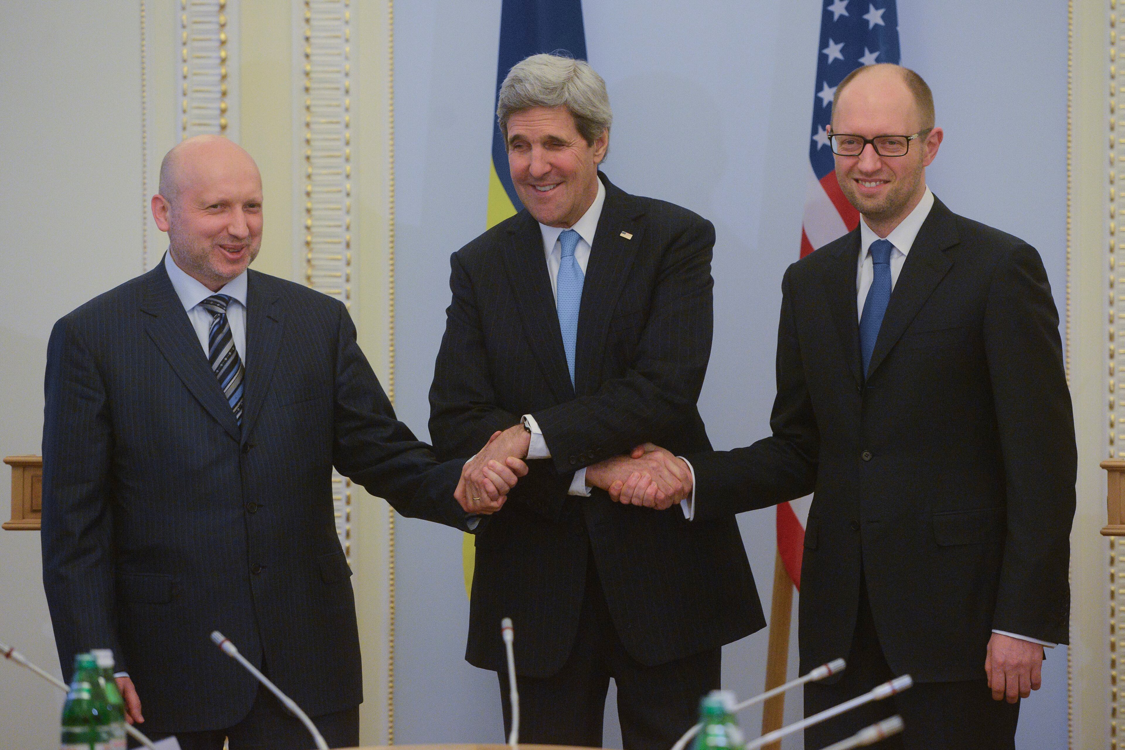 U.S. Secretary of State John Kerry, center, greets Ukrainian Prime Minister Arseniy Yatsenyuk, right, and parliament speaker Oleksandr Turchynov prior their meting in Kiev, Ukraine, Tuesday, March, 4, 2014. In a somber show of U.S. support for Ukraine's new leadership, Secretary of State John Kerry walked the streets Tuesday where nearly 100 anti-government protesters were gunned down by police last month, and promised beseeching crowds that American aid is on the way. The Obama administration announced a $1 billion energy subsidy package in Washington as Kerry was arriving in Kiev.( (AP Photo/Andrew Kravchenko, pool)