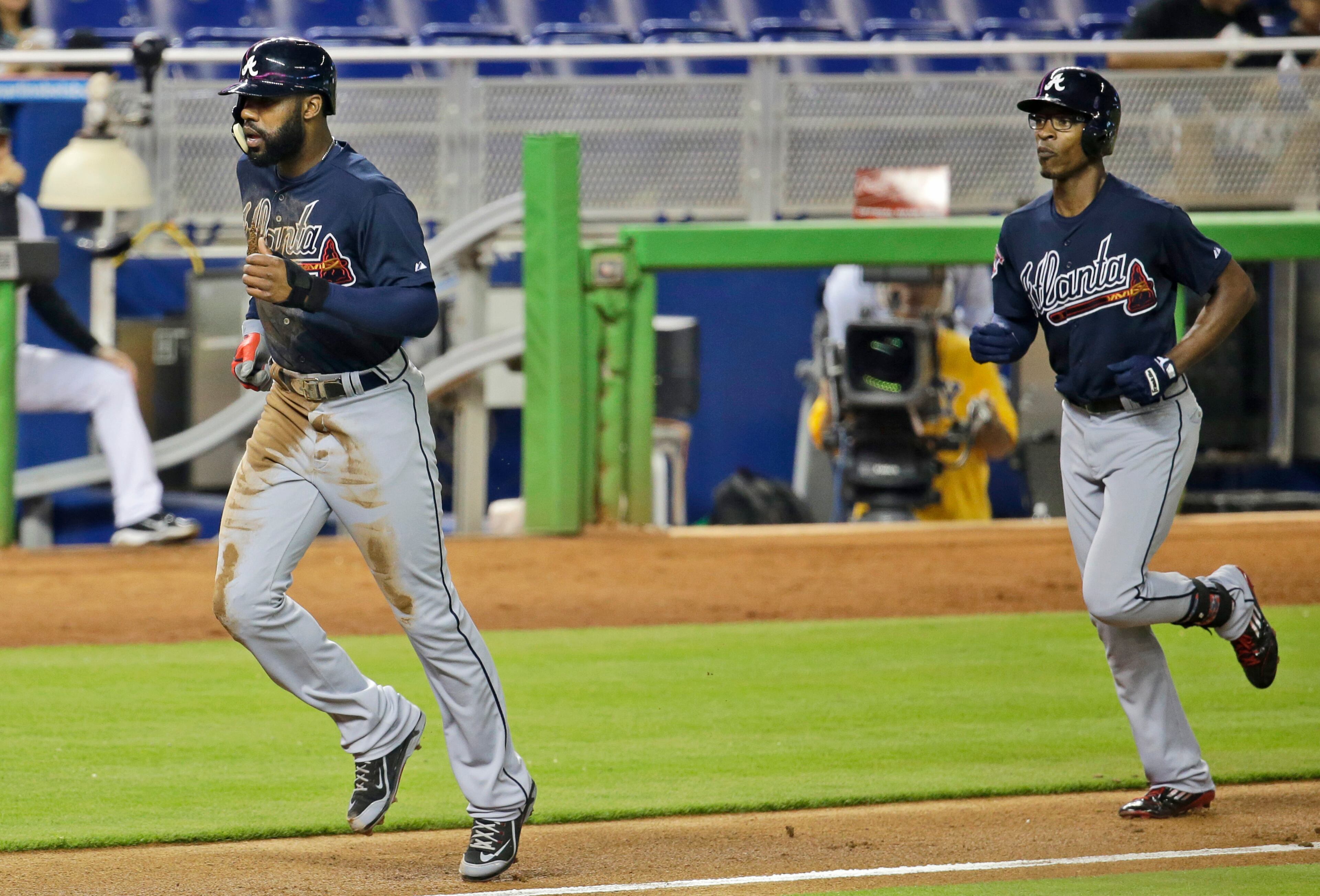 Atlanta Braves' Jason Heyward, left, and B.J. Upton, right, run the bases after Upton hit a three-run home run in the third inning of a baseball game against the Miami Marlins, Thursday, May 1, 2014, in Miami. (AP Photo/Lynne Sladky)
