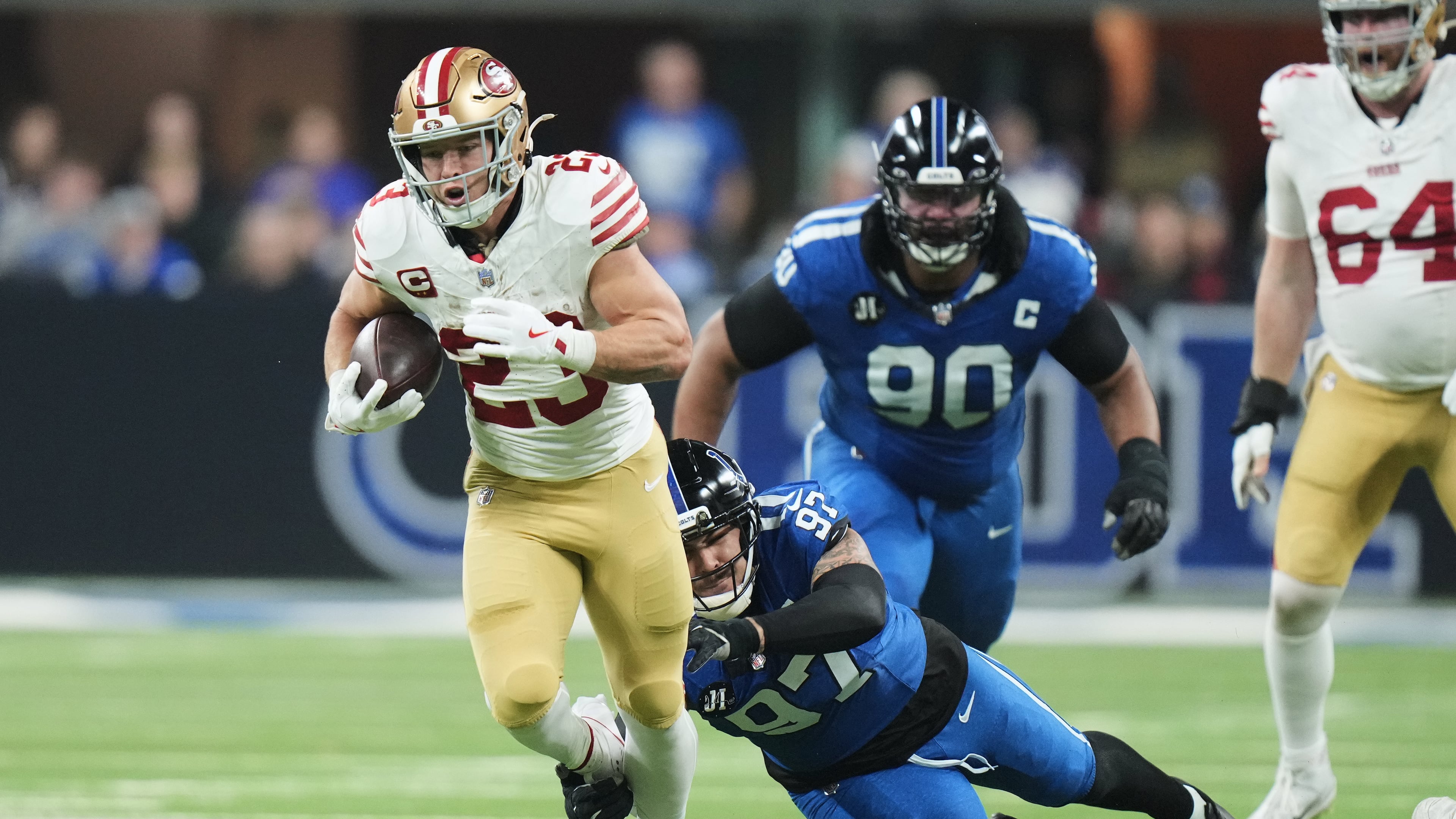San Francisco 49ers running back Christian McCaffrey (23) runs past Indianapolis Colts defensive end Laiatu Latu (97) and defensive tackle Grover Stewart (90) during the first half of an NFL football game, Monday, Dec. 22, 2025, in Indianapolis. (AP Photo/AJ Mast)